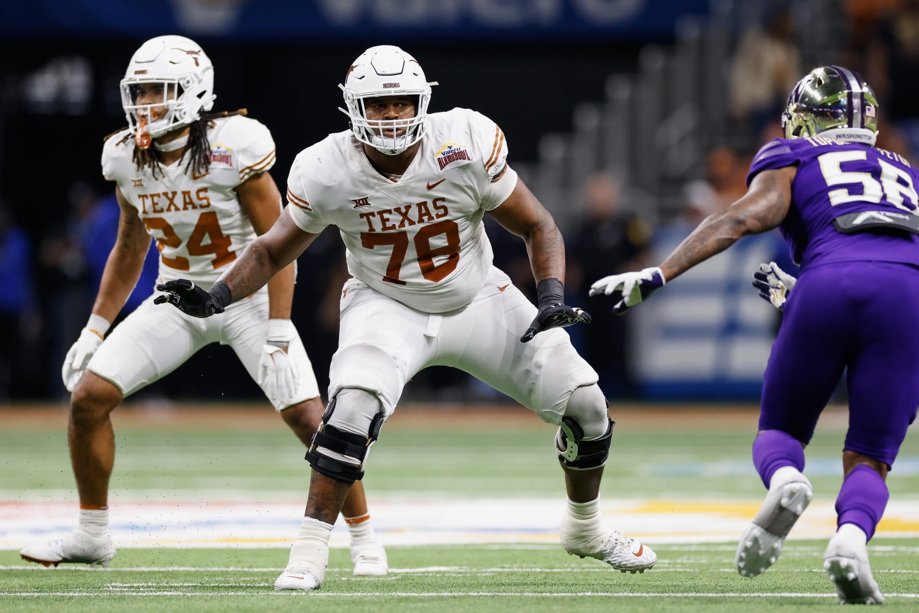 SAN ANTONIO, TEXAS - DECEMBER 29: Kelvin Banks Jr. #78 of the Texas Longhorns blocks Zion Tupuola-Fetui #58 of the Washington Huskies in the second half during the Valero Alamo Bowl at Alamodome on December 29, 2022 in San Antonio, Texas. (Photo by Tim Warner/Getty Images)