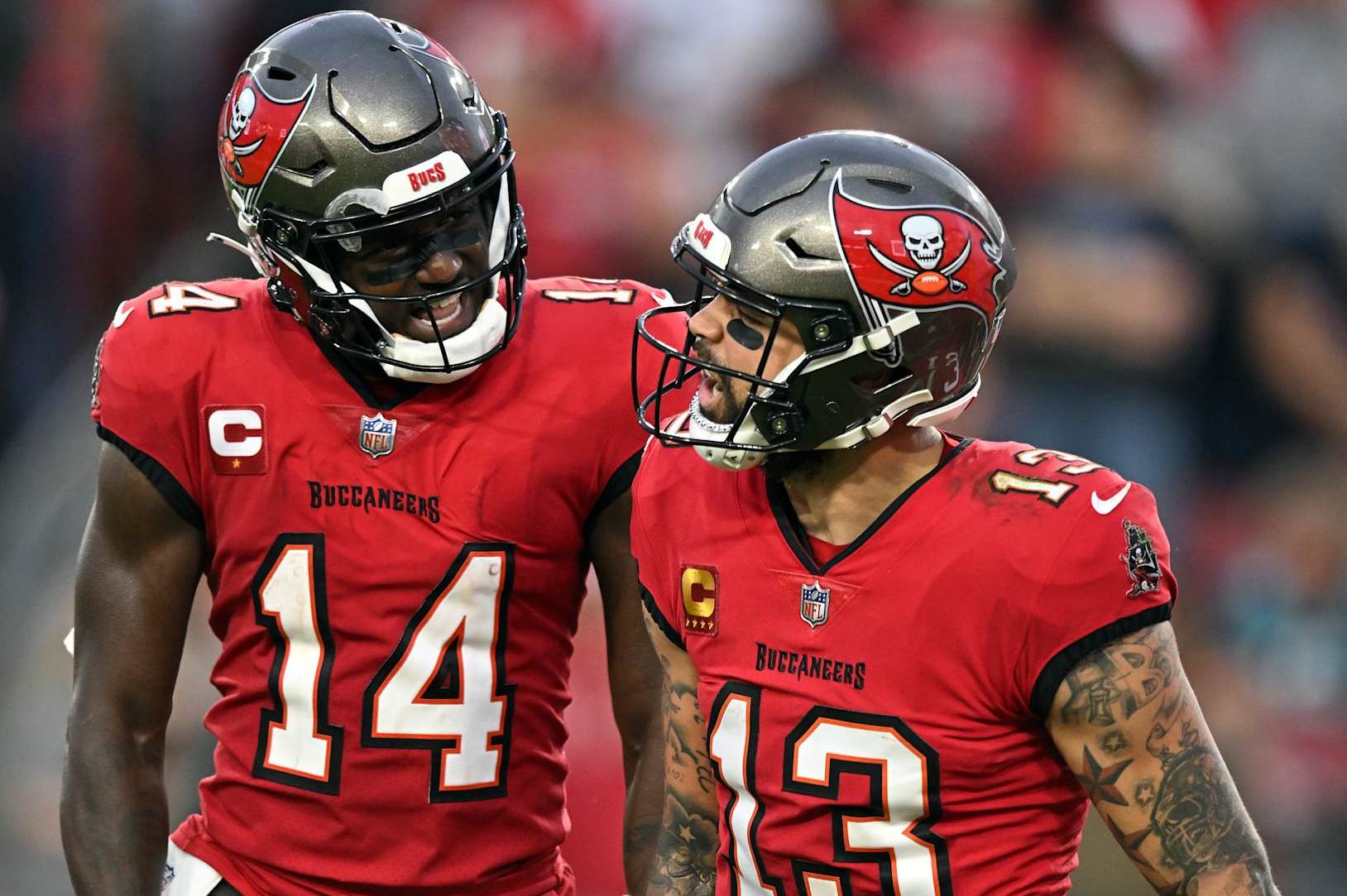 TAMPA, FLORIDA - DECEMBER 24: Mike Evans #13 of the Tampa Bay Buccaneers is congratulated by Chris Godwin #14 after scoring a touchdown reception against the Jacksonville Jaguars during the second quarter at Raymond James Stadium on December 24, 2023 in Tampa, Florida. (Photo by Julio Aguilar/Getty Images)