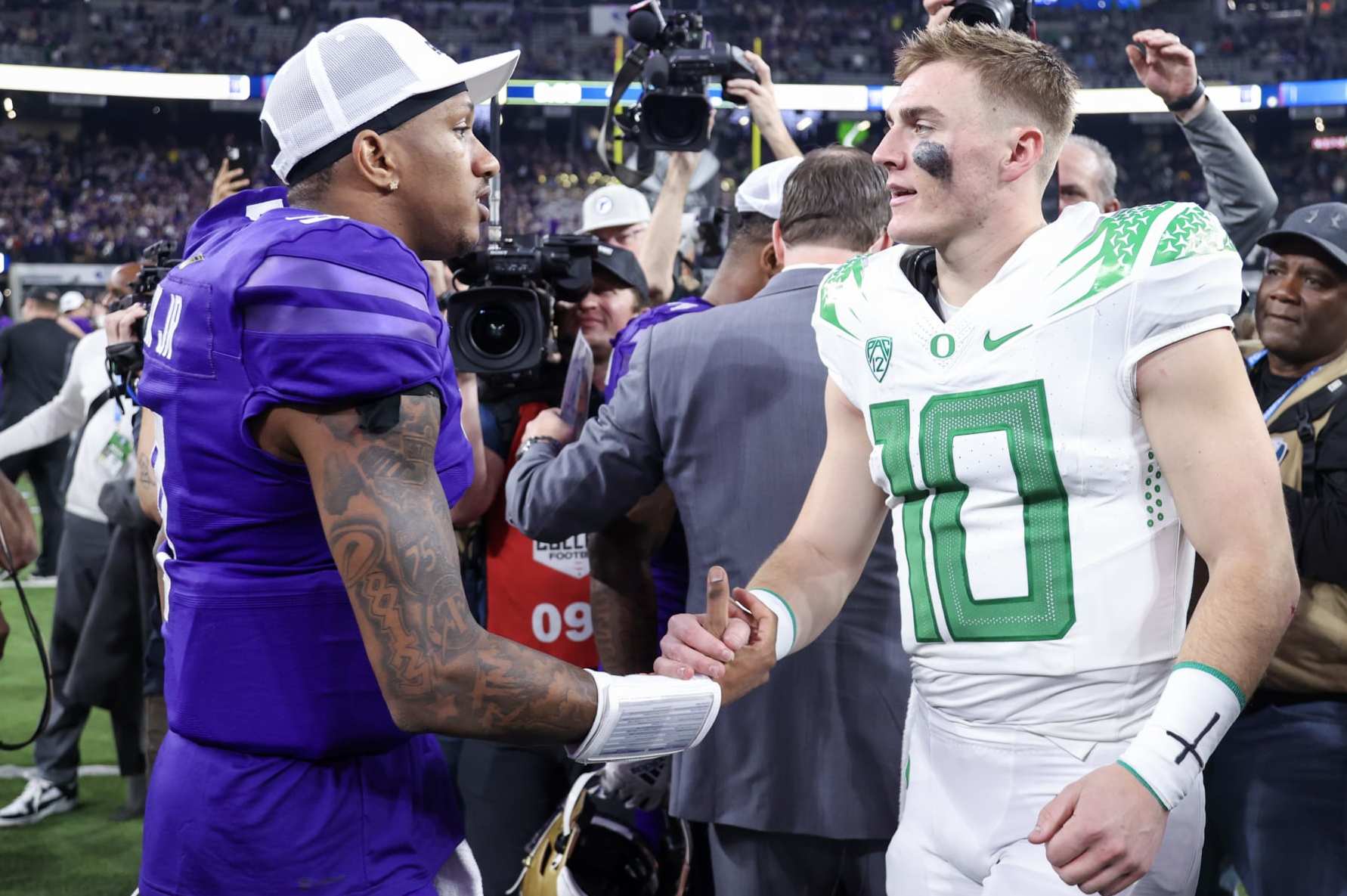 LAS VEGAS, NEVADA - DECEMBER 01: Michael Penix Jr. #9 of the Washington Huskies and Bo Nix #10 of the Oregon Ducks shake hands after Washington's win 34-31 during the Pac-12 Championship at Allegiant Stadium on December 01, 2023 in Las Vegas, Nevada. (Photo by Ian Maule/Getty Images)
