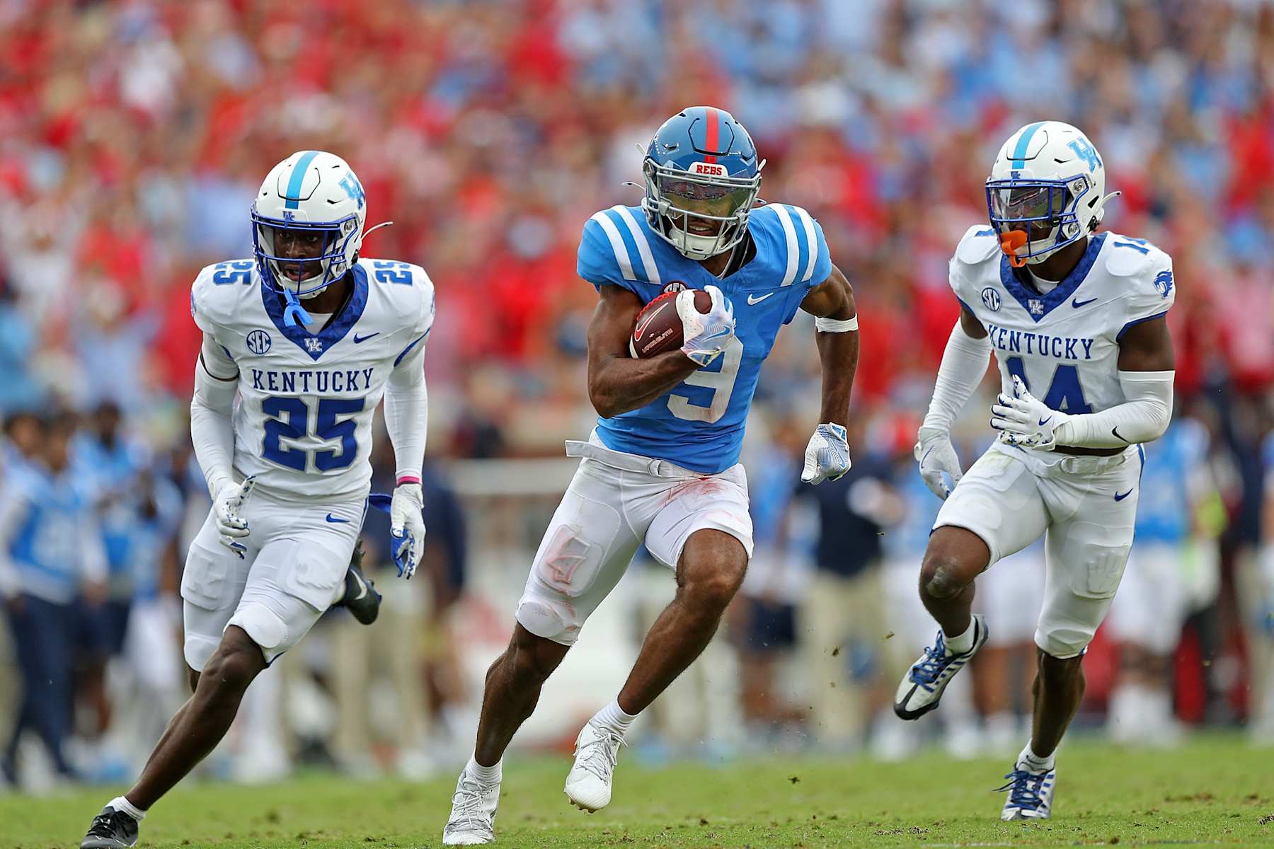 Ole Miss wide receiver Tre Harris runs away from Kentucky Wildcats defenders.