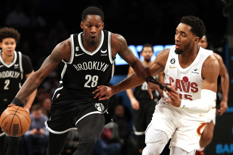 NEW YORK, NEW YORK - MARCH 21: Dorian Finney-Smith #28 of the Brooklyn Nets dribbles against Donovan Mitchell #45 of the Cleveland Cavaliers during their game at Barclays Center on March 21, 2023 in New York City. User expressly acknowledges and agrees that, by downloading and or using this photograph, User is consenting to the terms and conditions of the Getty Images License Agreement. (Photo by Al Bello/Getty Images)