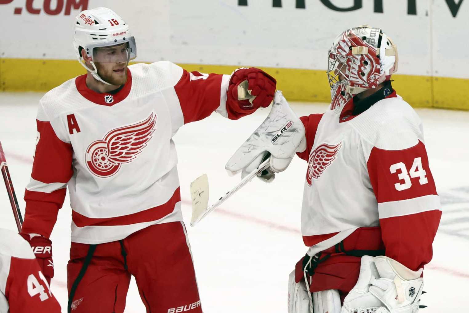 Detroit Red Wings goaltender Alex Lyon (34) celebrates a 5-3 victory with center Andrew Copp (18) following the third period of an NHL hockey game against the Buffalo Sabres Tuesday, Dec. 5, 2023, in Buffalo, N.Y. (AP Photo/Jeffrey T. Barnes)