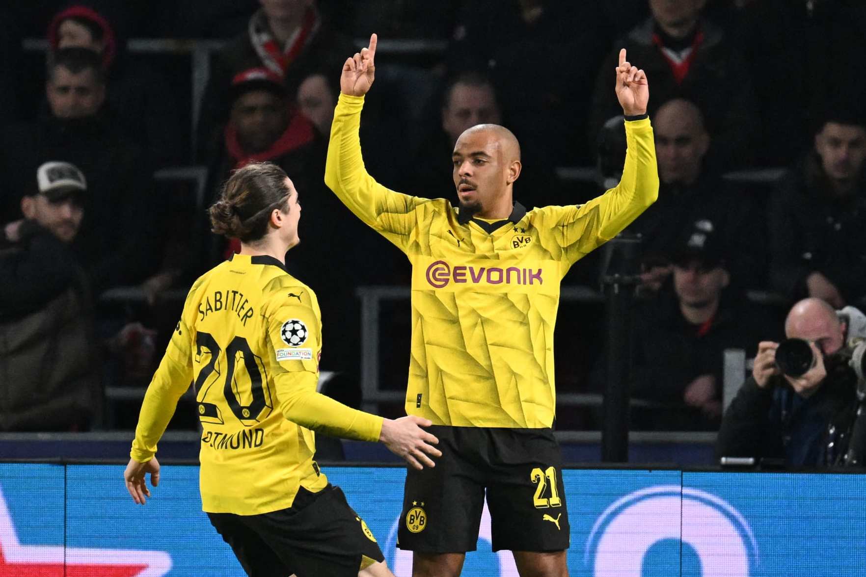 Dortmund's Dutch forward #21 Donyell Malen (R) celebrates scoring the first goal of the match during the UEFA Champions League round of 16, first leg football match between against PSV Eindhoven and Borussia Dortmund at the The Philips Stadium, in Eindhoven on February 20, 2024. (Photo by JOHN THYS / AFP) (Photo by JOHN THYS/AFP via Getty Images)