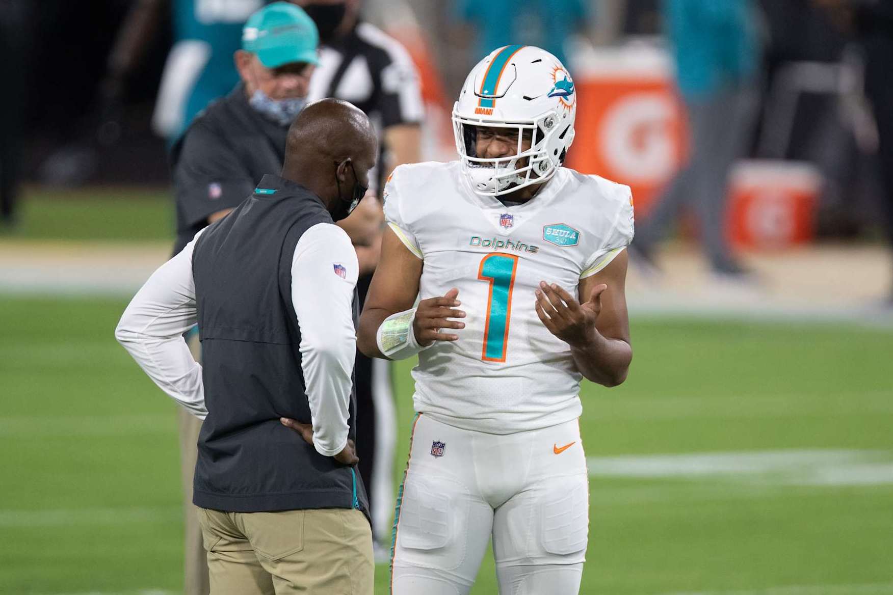 JACKSONVILLE, FL - SEPTEMBER 24: Tua Tagovailoa #1 of the Miami Dolphins talks with head coach Brian Flores during warm ups prior to an NFL football game against the Jacksonville Jaguars at TIAA Bank Field on September 24, 2020 in Jacksonville, Florida. (Photo by Perry Knotts/Getty Images)