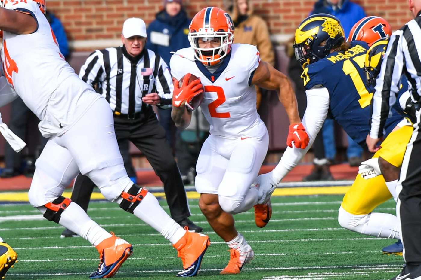 ANN ARBOR, MICHIGAN - NOVEMBER 19: Chase Brown #2 of the Illinois Fighting Illini runs with the ball against Braiden McGregor #17 of the Michigan Wolverines during the first half at Michigan Stadium on November 19, 2022 in Ann Arbor, Michigan. (Photo by Aaron J. Thornton/Getty Images)