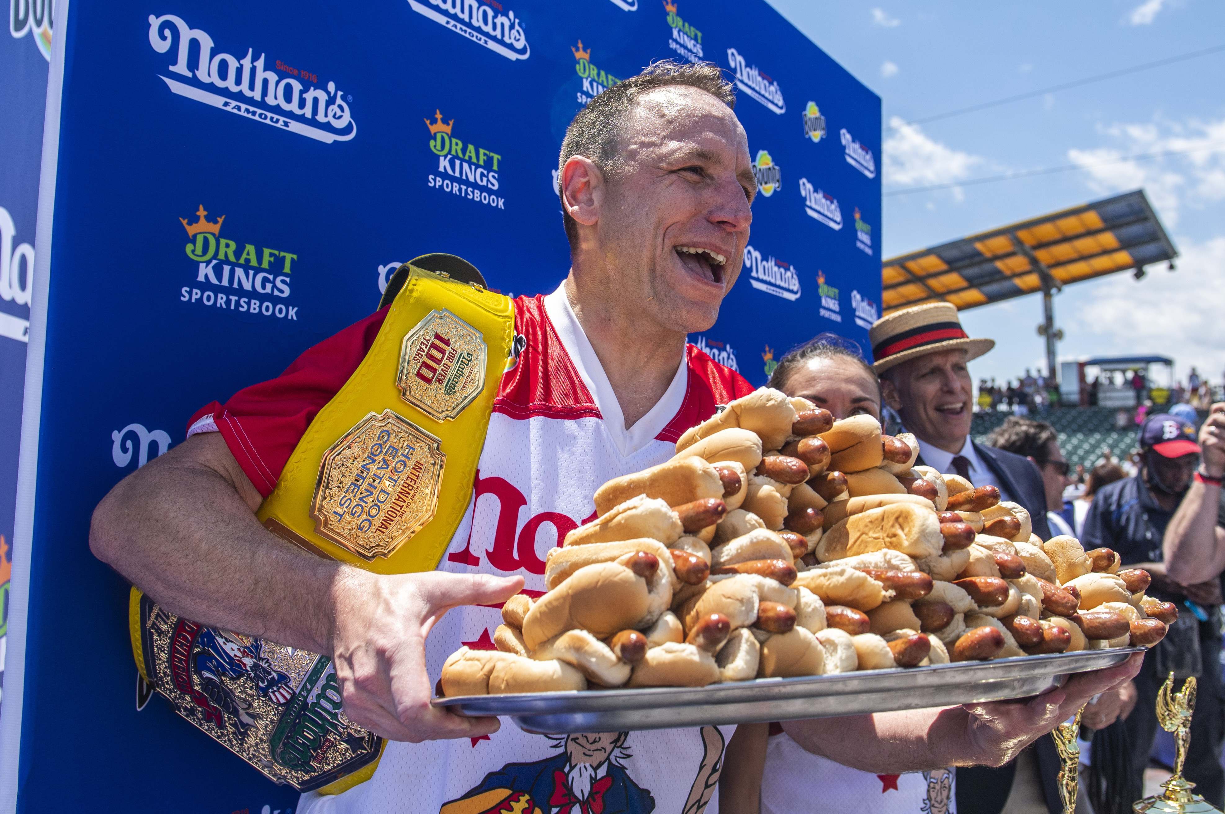 Winners Joey Chestnut and Michelle Lesco, obscured behind hot dogs, pose at the Nathan's Famous Fourth of July International Hot Dog-Eating Contest in Coney Island's Maimonides Park on Sunday, July 4, 2021, in the Brooklyn borough of New York. (AP Photo/Brittainy Newman)