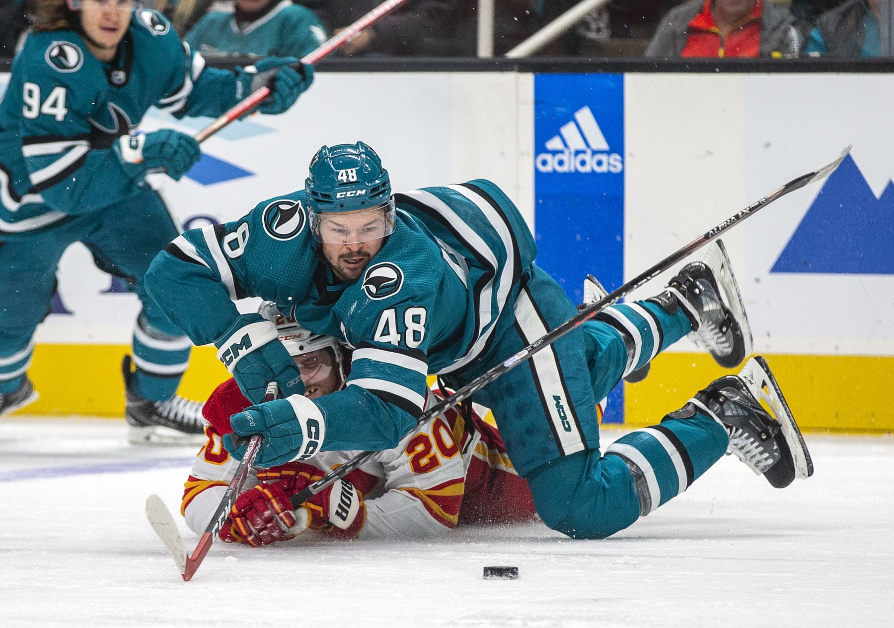 SAN JOSE, CA - DECEMBER 18: San Jose Sharks center Thomas Hertel (48) falls over Calgary Flames right winger Blake Coleman (20) during the second period of a regular season NHL hockey game between the Calgary Flames and San Jose Sharks. On December 18, 2022, at the SAP Center, in San Jose, California. (Photo by Tony Deng/Icon Sportswire via Getty Images)