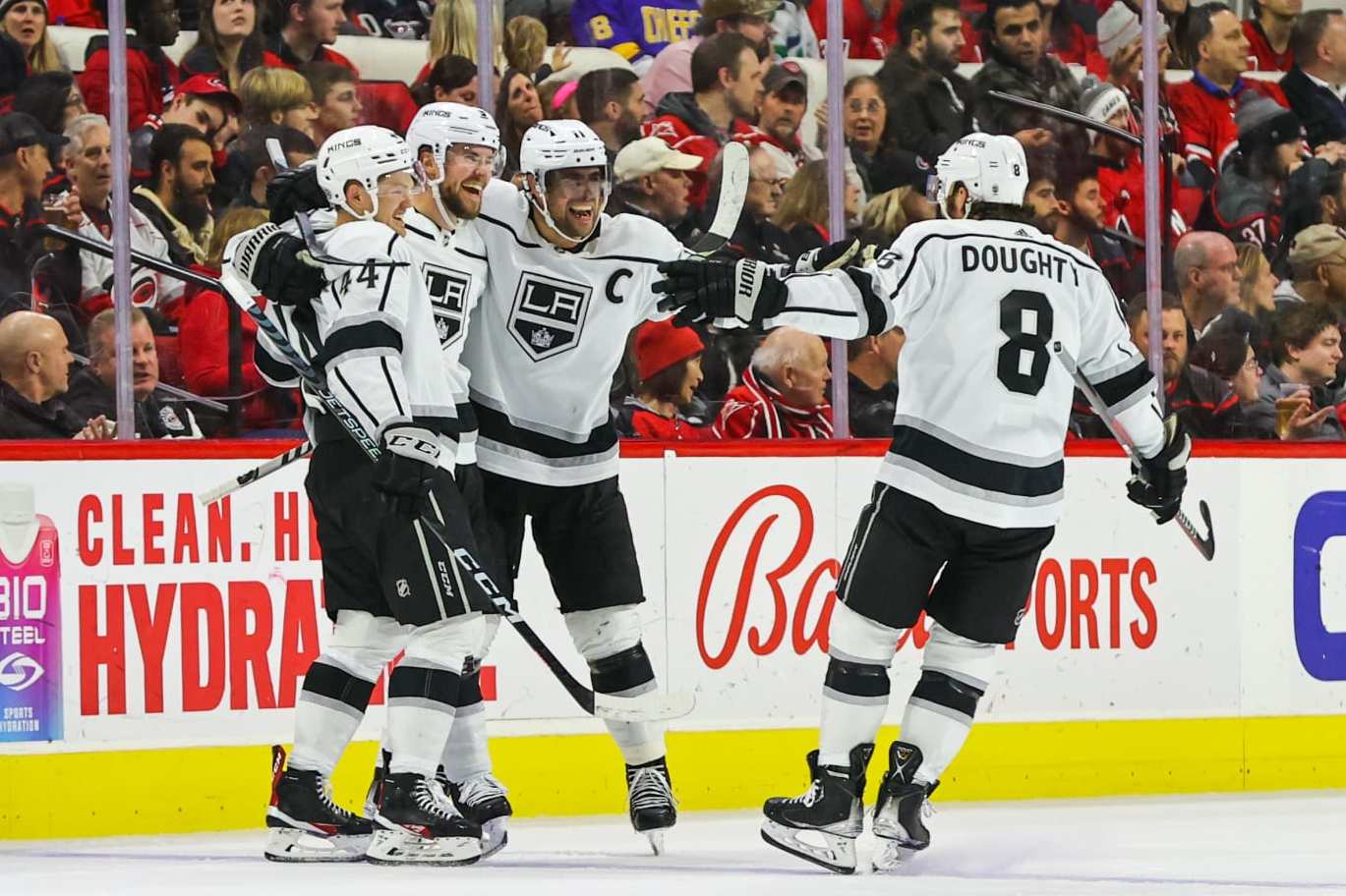 RALEIGH, NC - JANUARY 31: Anze Kopitar #11 of the Los Angeles Kings celebrates his goal with his teammates, Alexander Edler #2, Mikey Anderson #44 and Drew Doughty #8 during the second period of the game against the Carolina Hurricanes at PNC Arena on January 31, 2023 in Raleigh, North Carolina. (Photo by Jaylynn Nash/Getty Images)