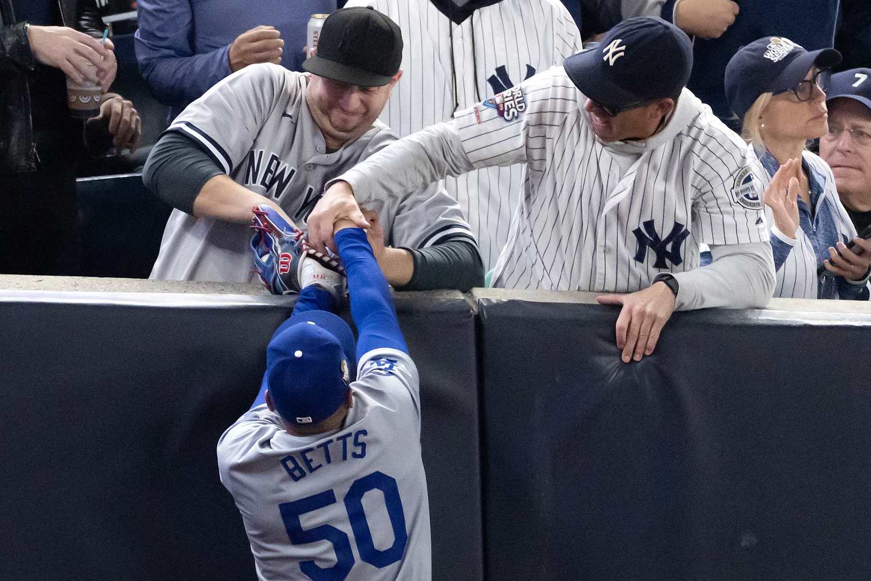 NEW YORK, NEW YORK - OCTOBER 29: Fans interfere with Mookie Betts #50 of the Los Angeles Dodgers as he attempts to catch a fly ball in foul territory during the first inning of Game Four of the 2024 World Series against the New York Yankees at Yankee Stadium on October 29, 2024 in the Bronx borough of New York City. The play resulted in an out. (Photo by Al Bello/Getty Images)