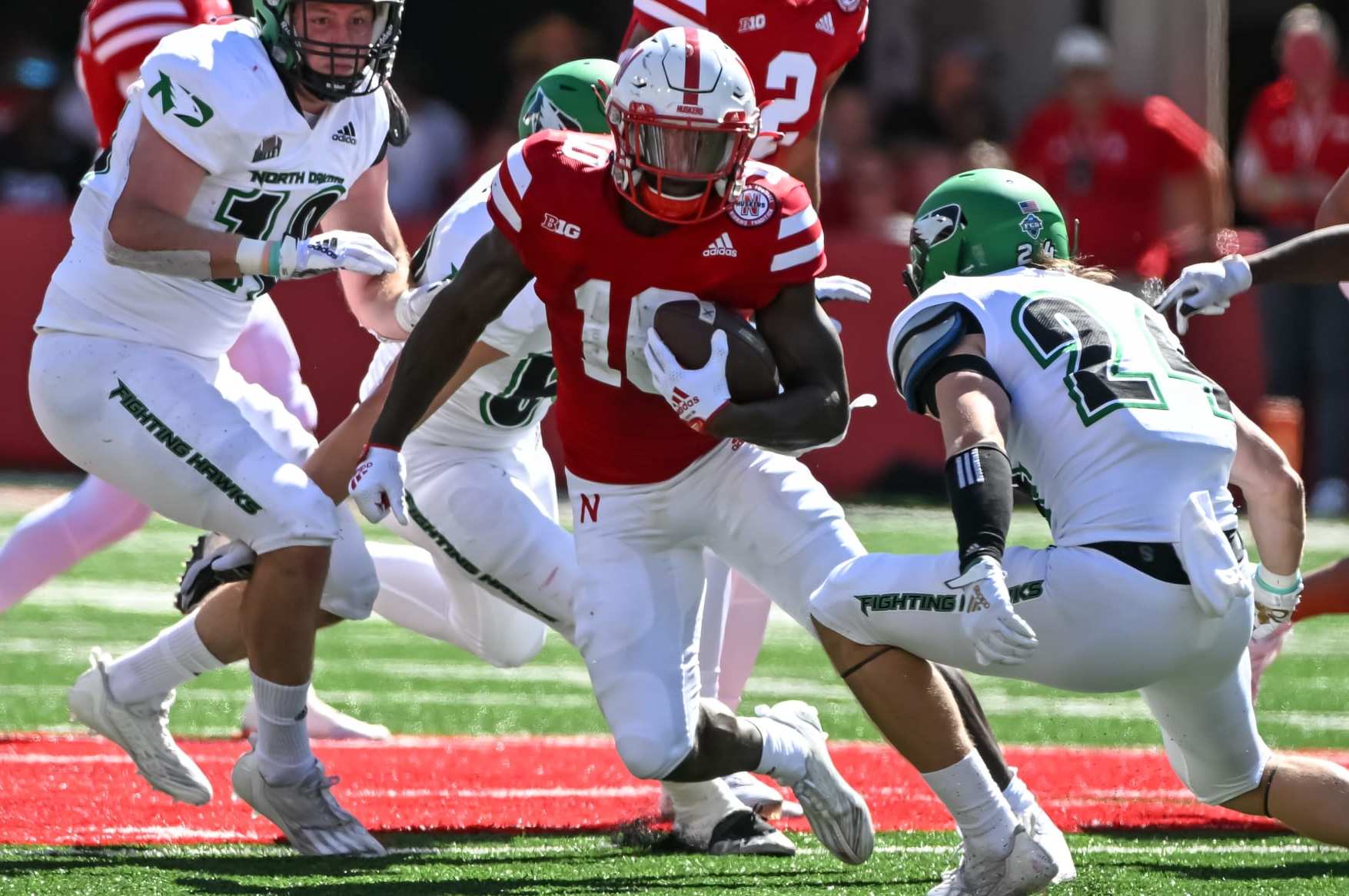 LINCOLN, NE - SEPTEMBER 3: Running back Anthony Grant #10 of the Nebraska Cornhuskers runs from defensive back Kadon Kauppinen #24 of the North Dakota Fighting Hawks in the first quarter at Memorial Stadium on September 3, 2022 in Lincoln, Nebraska. (Photo by Steven Branscombe/Getty Images)