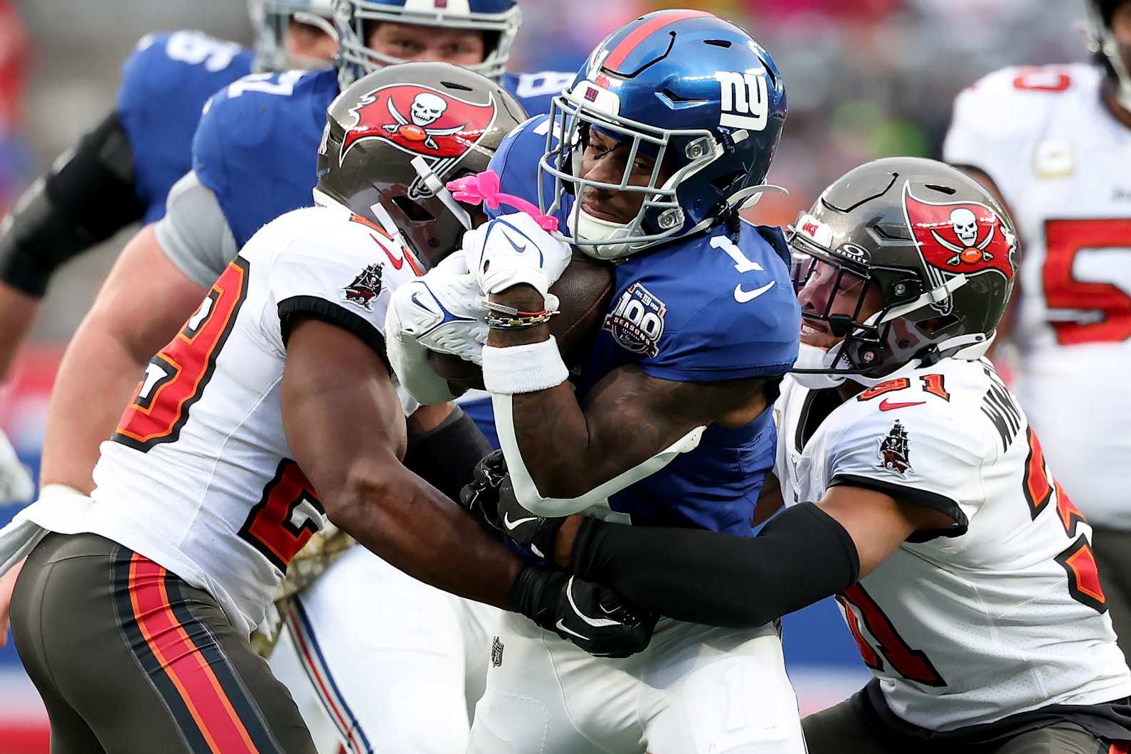 EAST RUTHERFORD, NEW JERSEY - NOVEMBER 24: Malik Nabers #1 of the New York Giants carries the ball as Christian Izien #29 and Antoine Winfield Jr. #31 of the Tampa Bay Buccaneers defend at MetLife Stadium on November 24, 2024 in East Rutherford, New Jersey. (Photo by Elsa/Getty Images)