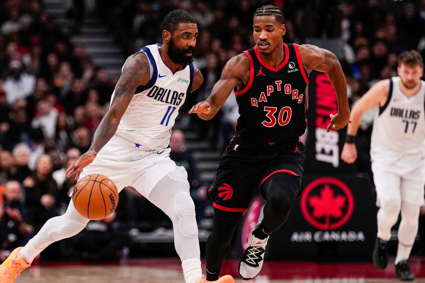 TORONTO, ON - DECEMBER 7: Kyrie Irving #11 of the Dallas Mavericks dribbles the ball against Ochai Agbaji #30 of the Toronto Raptors at Scotiabank Arena on December 7, 2024 in Toronto, Ontario, Canada. NOTE TO USER: User expressly acknowledges and agrees that, by downloading and/or using this Photograph, user is consenting to the terms and conditions of the Getty Images License Agreement. (Photo by Andrew Lahodynskyj/Getty Images)