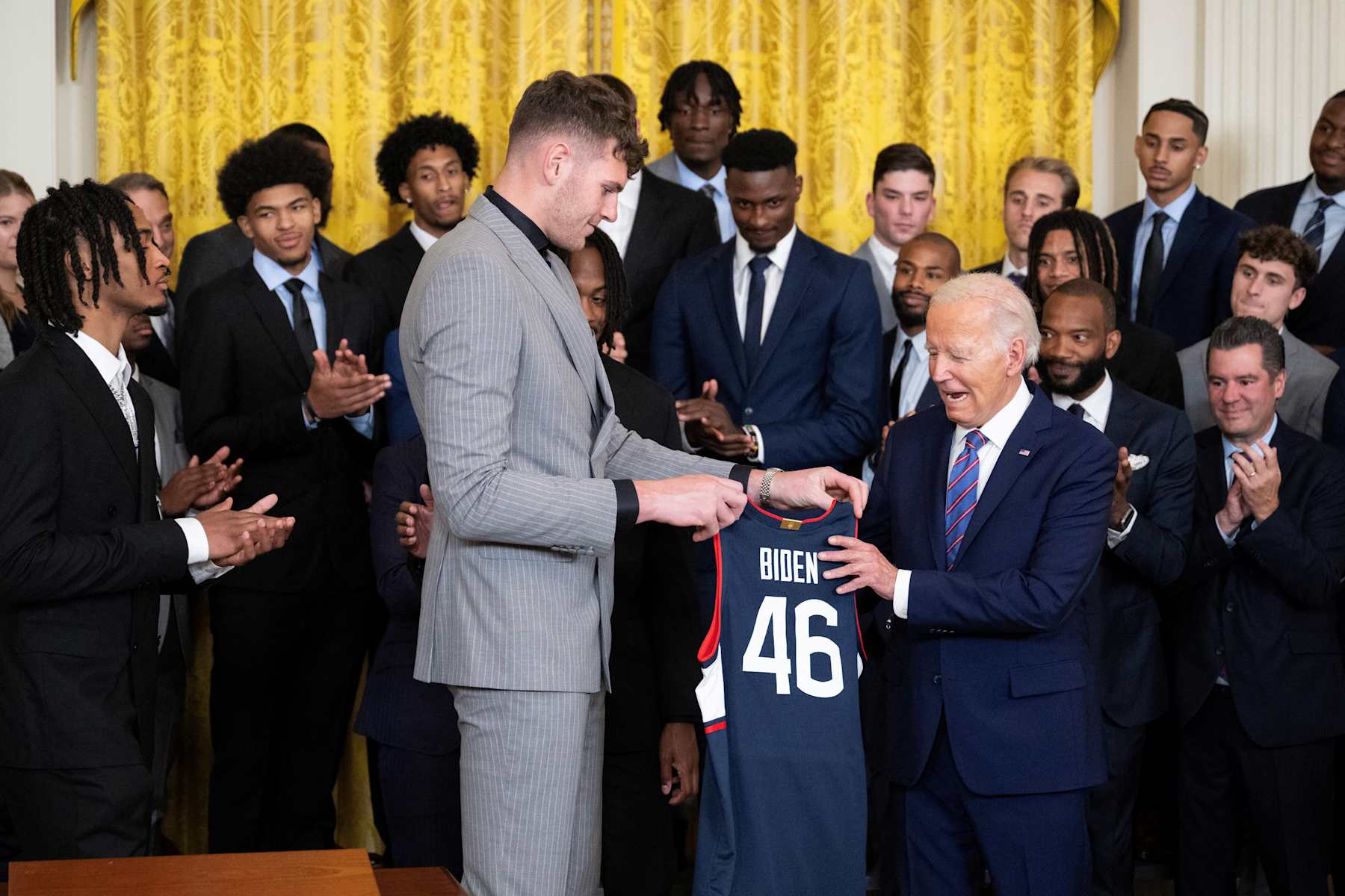 Donovan Clingan gives a jersey to US President Joe Biden during an event to celebrate the University of Connecticut men's basketball team for their 2023-2024 championship season in the East Room of the White House on September 10, 2024 in Washington, DC. (Photo by Drew ANGERER / AFP) (Photo by DREW ANGERER/AFP via Getty Images)