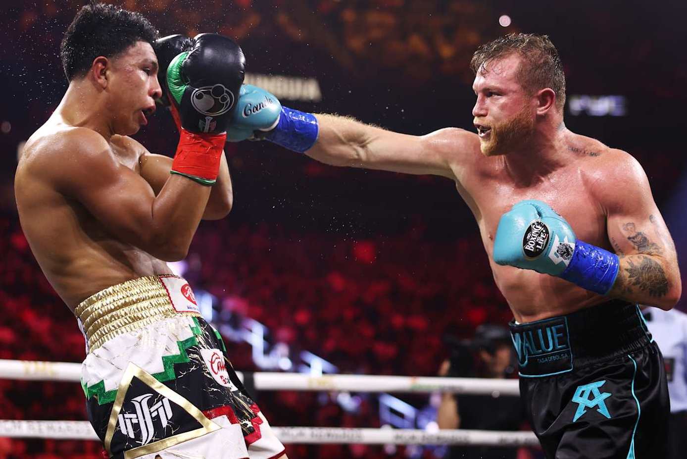 LAS VEGAS, NEVADA - MAY 04: Canelo Alvarez (R) lands a punch on Jaime Munguia (L) during their super middleweight title fight at T-Mobile Arena on May 04, 2024 in Las Vegas, Nevada. (Photo by Cris Esqueda/Golden Boy/Getty Images)