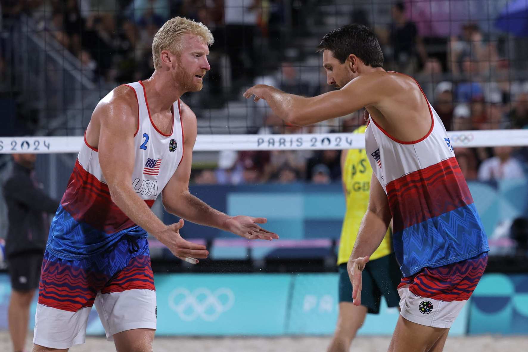 US' #02 Chase Budinger and US' #01 Miles Evans celebrate a point in the men's lucky loser beach volleyball match between Australia and USA during the Paris 2024 Olympic Games at the Eiffel Tower Stadium in Paris on August 3, 2024. (Photo by Thomas SAMSON / AFP) (Photo by THOMAS SAMSON/AFP via Getty Images)