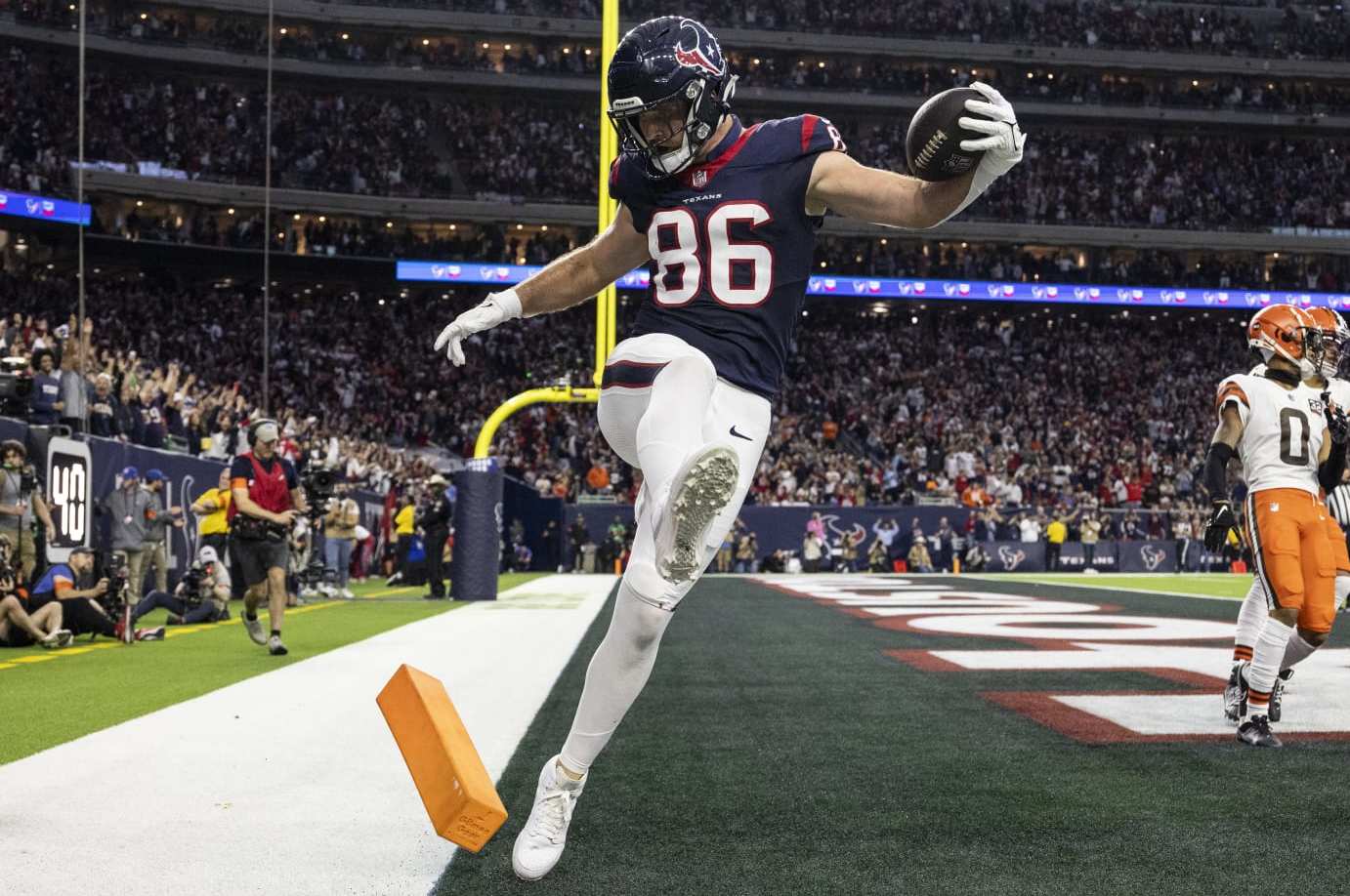 HOUSTON, TEXAS - JANUARY 13: Dalton Schultz #86 of the Houston Texans celebrates by kicking the pylon after completing a pass for a touchdown during an NFL wild-card playoff football game between the Houston Texans and the Cleveland Browns at NRG Stadium on January 13, 2024 in Houston, Texas. (Photo by Michael Owens/Getty Images)