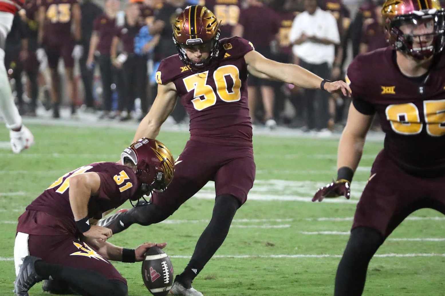 TEMPE, ARIZONA - OCTOBER 11: Kanyon Floyd #31 of the Arizona State Sun Devils holds the ball for teammate Ian Hershey #30 of the Arizona State Sun Devils who makes the extra point in the third quarter of the Utah Utes versus the Arizona State Sun Devils football game at Mountain America Stadium on October 11, 2024 in Tempe, Arizona. (Photo by Bruce Yeung/Getty Images)