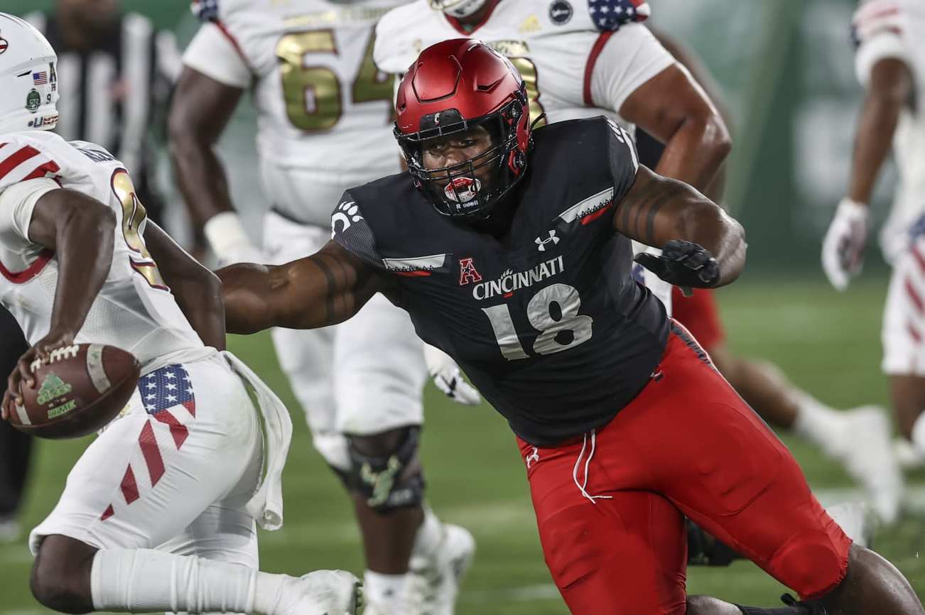 TAMPA, FL - NOVEMBER 12: Cincinnati Bearcats defensive lineman Jowon Briggs (18) puts pressure on South Florida Bulls quarterback Timmy McClain (9) during the college football game between the Cincinnati Bearcats and South Florida Bulls on November  12, 2021 at Raymond James Stadium in Tampa, FL. (Photo by Mark LoMoglio/Icon Sportswire via Getty Images)
