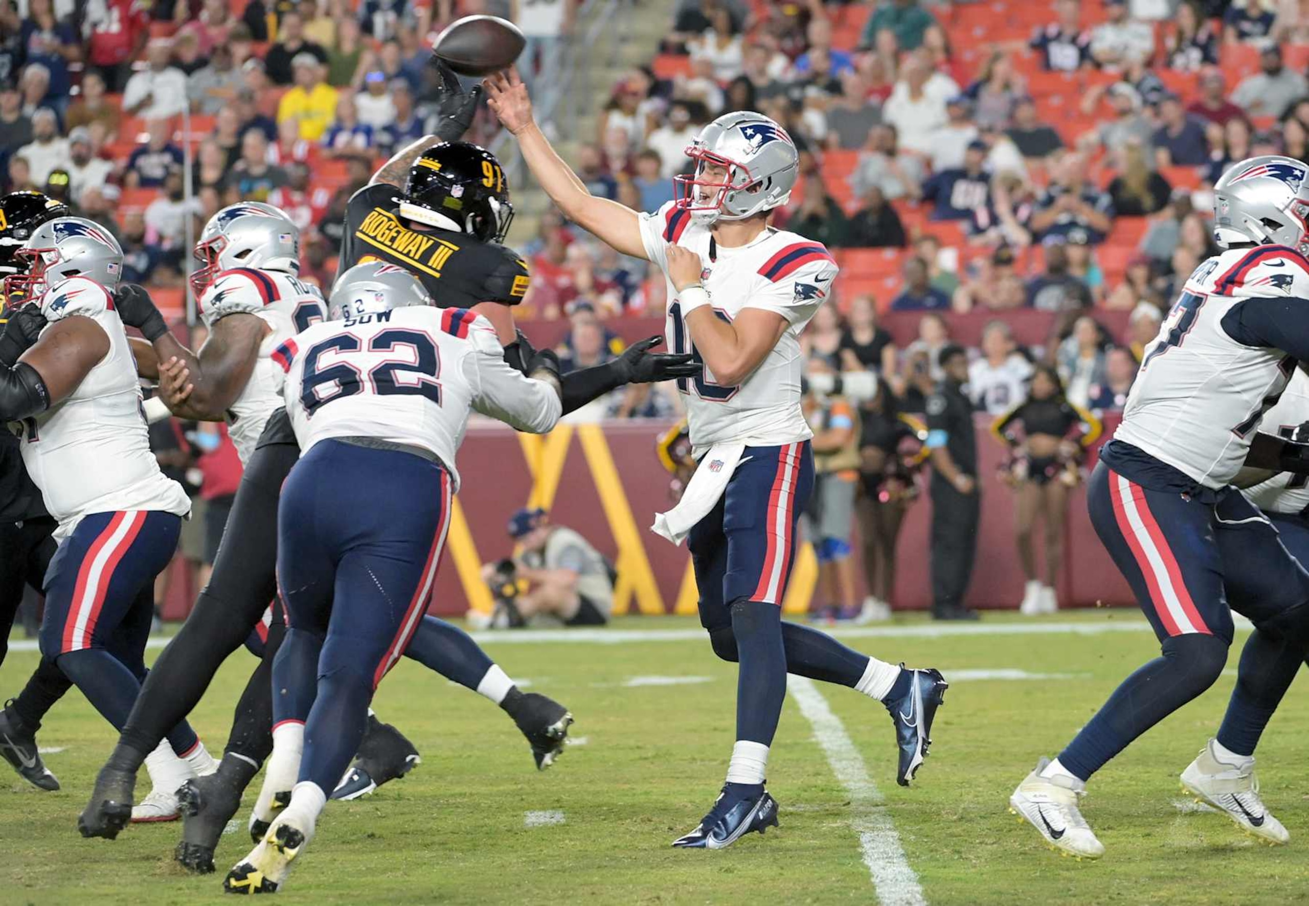 LANDOVER, MD - AUGUST 25: New England Patriots quarterback Drake Maye (10) passes under pressure from Washington Commanders defensive tackle John Ridgeway III (91) during the pre season NFL game between the New Englands Patriots and the Washington Commanders on August 25, 2024 at Commanders Field in Landover, MD. (Photo by Mark Goldman/Icon Sportswire via Getty Images) LANDOVER, MD - AUGUST 25: New England Patriots quarterback Drake Maye (10) passes under pressure from Washington Commanders defensive tackle John Ridgeway III (91) during the pre season NFL game between the New Englands Patriots and the Washington Commanders on August 25, 2024 at Commanders Field in Landover, MD. (Photo by Mark Goldman/Icon Sportswire via Getty Images)
