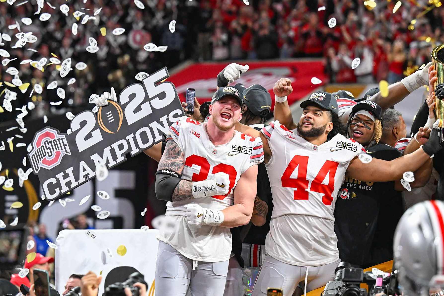 ATLANTA, GA  JANUARY 20:  Defensive End Jack Sawyer #33 of the Ohio State Buckeyes and teammate JT Tuimoloau #44 celebrate with the winning trophy following the conclusion of the the Ohio State Buckeyes versus Notre Dame Fighting Irish College Football Playoff National Championship game on January 20, 2025, at Mercedes-Benz Stadium in Atlanta, GA.  (Photo by Rich von Biberstein/Icon Sportswire via Getty Images)