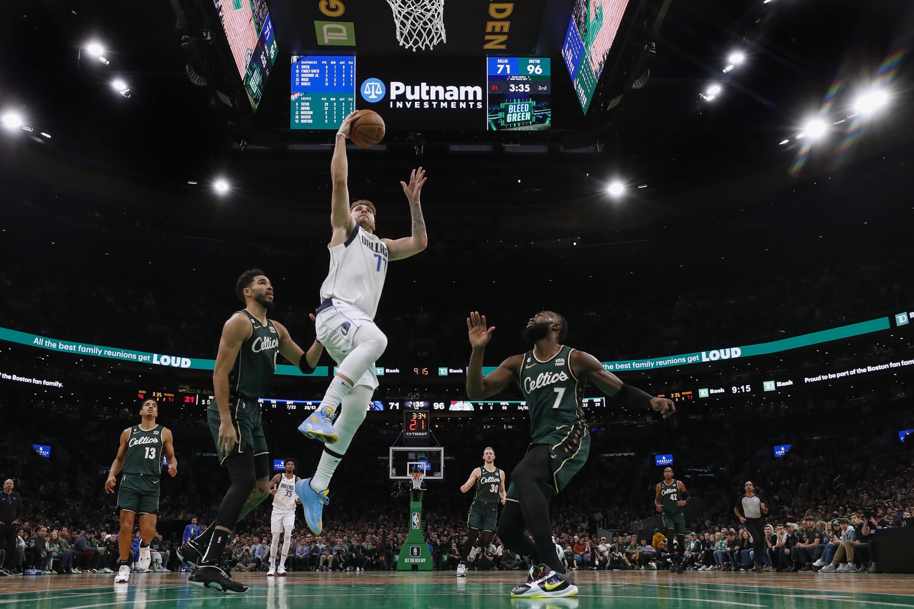 BOSTON, MA - NOVEMBER 23: Luka Doncic #77 of the Dallas Mavericks takes it to the basket past Jaylen Brown #7 of the Boston Celtics and Jayson Tatum during the third quarter at TD Garden on November 23, 2022 in Boston, Massachusetts. NOTE TO USER: User expressly acknowledges and agrees that, by downloading and/or using this Photograph, user is consenting to the terms and conditions of the Getty Images License Agreement. (Photo By Winslow Townson/Getty Images)
