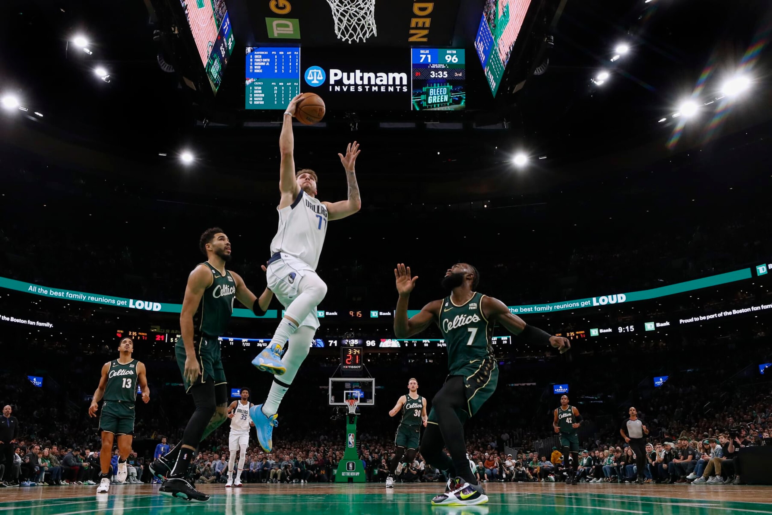 BOSTON, MA - NOVEMBER 23: Luka Doncic #77 of the Dallas Mavericks takes it to the basket past Jaylen Brown #7 of the Boston Celtics and Jayson Tatum during the third quarter at TD Garden on November 23, 2022 in Boston, Massachusetts. NOTE TO USER: User expressly acknowledges and agrees that, by downloading and/or using this Photograph, user is consenting to the terms and conditions of the Getty Images License Agreement. (Photo By Winslow Townson/Getty Images)