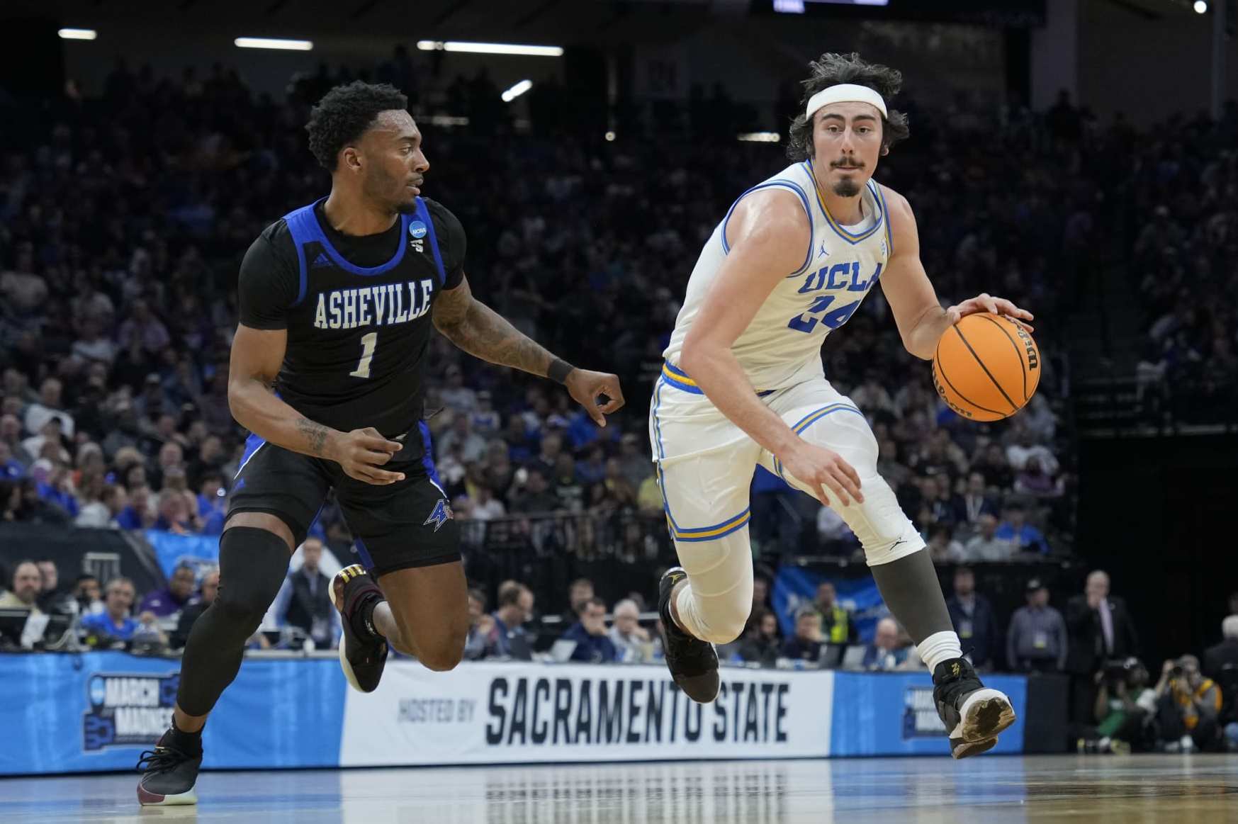 SACRAMENTO, CALIFORNIA - MARCH 16: Jaime Jaquez Jr. #24 of the UCLA Bruins works his way around Jamon Battle #1 of the North Carolina-Asheville Bulldogs during the first half in the first round of the NCAA Men's Basketball Tournament at Golden 1 Center on March 16, 2023 in Sacramento, California. (Photo by Thearon W. Henderson/Getty Images)