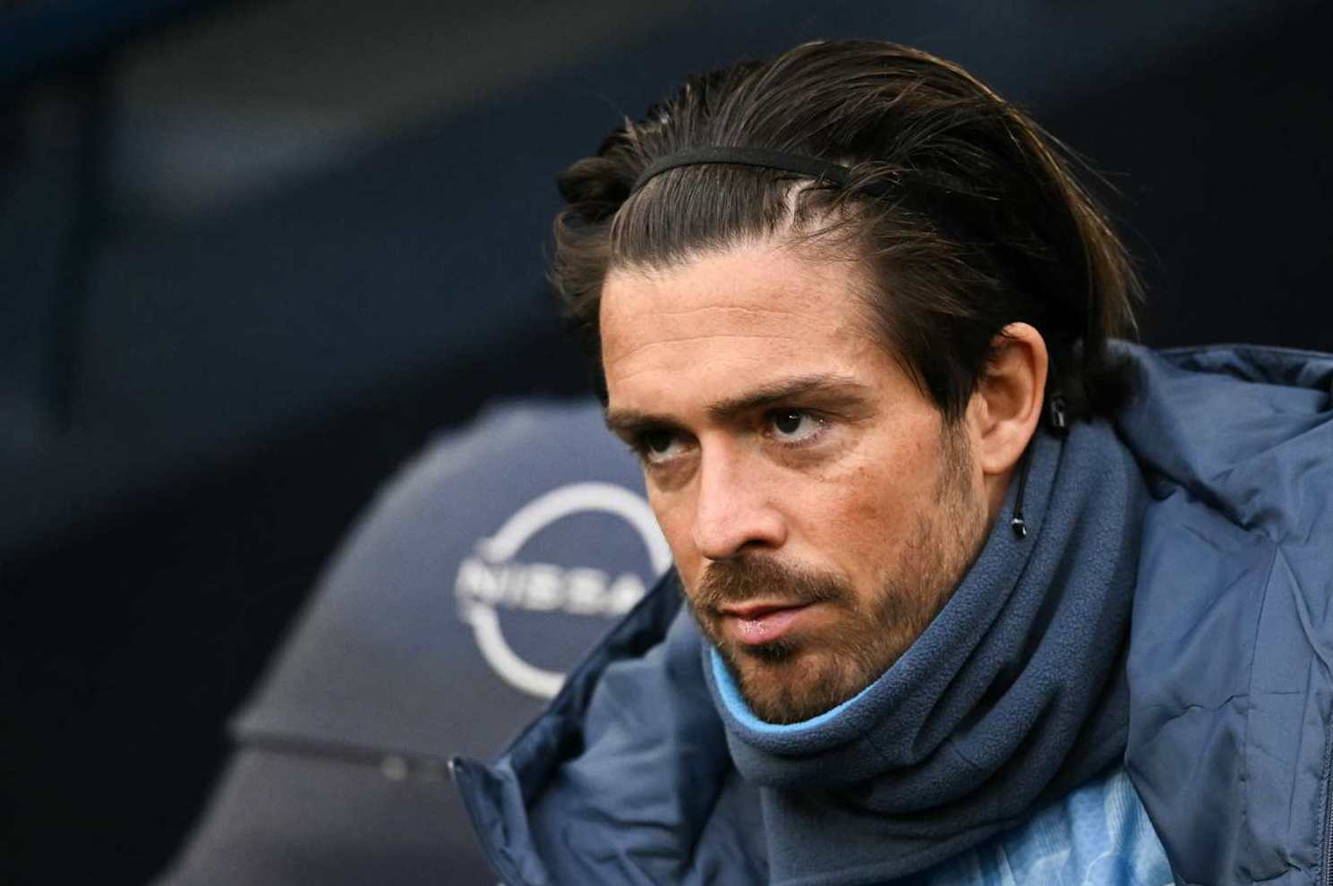 Manchester City's English midfielder #10 Jack Grealish reacts as he sits in on the bench during the English Premier League football match between Manchester City and West Ham United at the Etihad Stadium in Manchester, north west England, on January 4, 2025. (Photo by Oli SCARFF / AFP) / RESTRICTED TO EDITORIAL USE. No use with unauthorized audio, video, data, fixture lists, club/league logos or 'live' services. Online in-match use limited to 120 images. An additional 40 images may be used in extra time. No video emulation. Social media in-match use limited to 120 images. An additional 40 images may be used in extra time. No use in betting publications, games or single club/league/player publications. / (Photo by OLI SCARFF/AFP via Getty Images)
