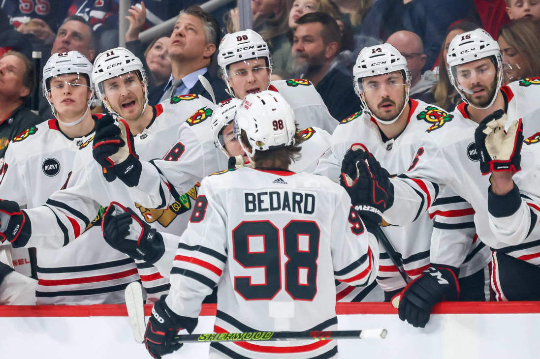 WINNIPEG, CANADA - DECEMBER 2: Connor Bedard #98 of the Chicago Blackhawks celebrates his first period goal against the Winnipeg Jets with teammates at the bench at the Canada Life Centre on December 2, 2023 in Winnipeg, Manitoba, Canada. (Photo by Jonathan Kozub/NHLI via Getty Images)
