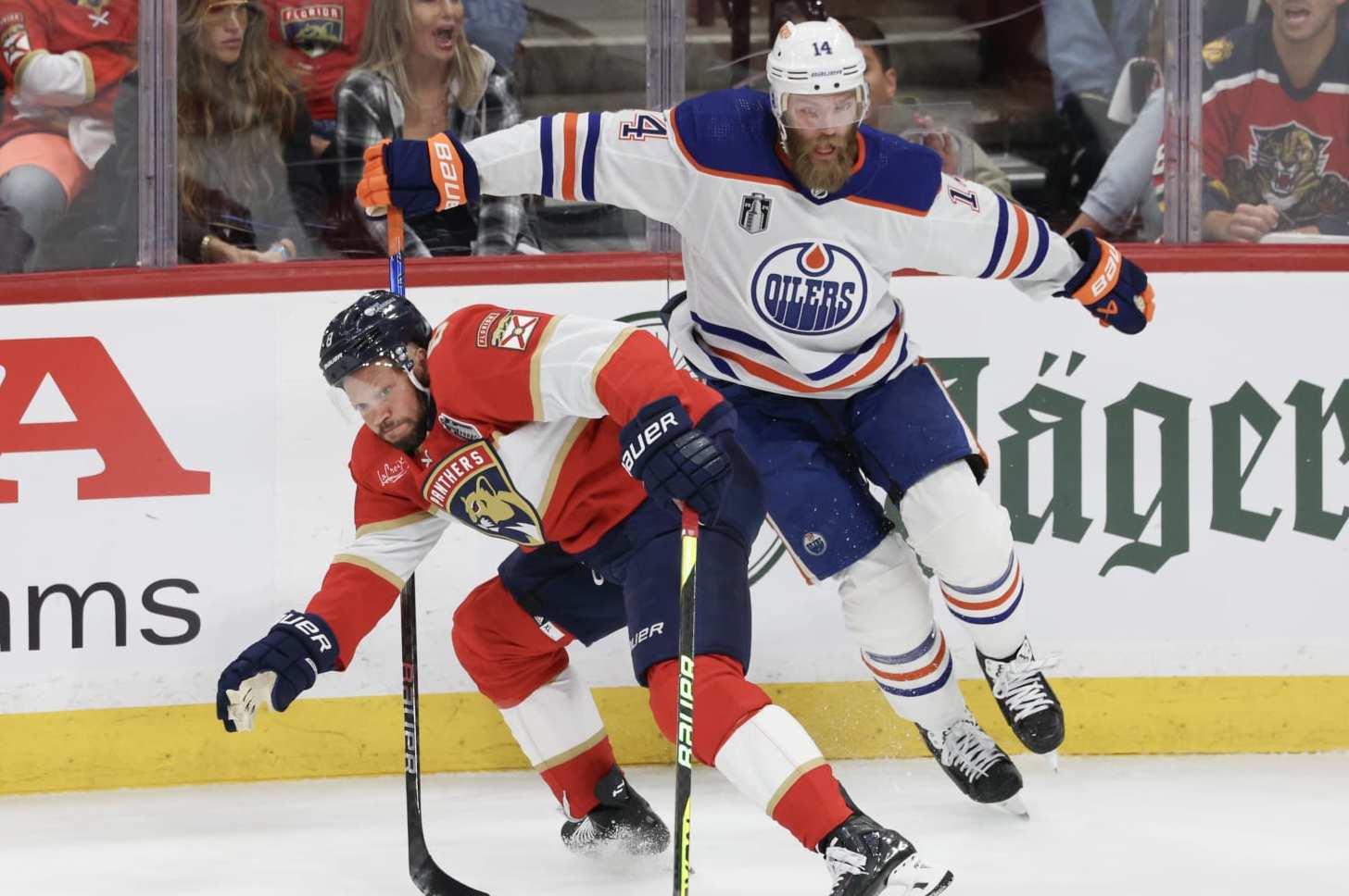 SUNRISE, FLORIDA - JUNE 08: Kyle Okposo #8 of the Florida Panthers collides with Mattias Ekholm #14 of the Edmonton Oilers during the first period in Game One of the 2024 Stanley Cup Final at Amerant Bank Arena on June 08, 2024 in Sunrise, Florida. (Photo by Elsa/Getty Images)
