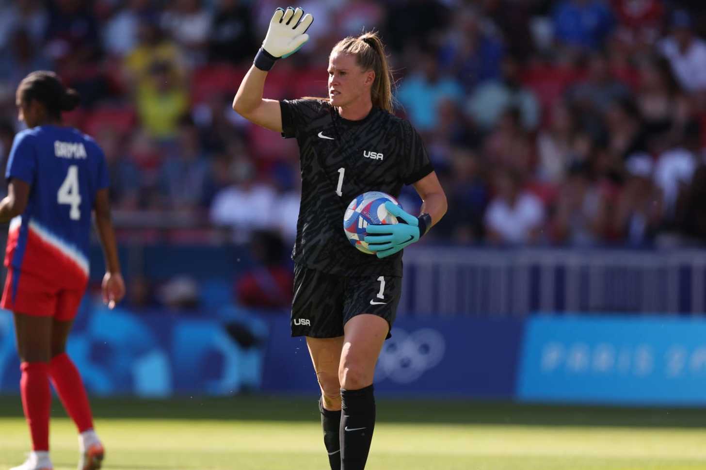 PARIS, FRANCE - AUGUST 10: Alyssa Naeher #1 of Team United States holds the ball and gestures to her teammates during the Women's Gold Medal match between Brazil and United States of America during the Olympic Games Paris 2024 at Parc des Princes on August 10, 2024 in Paris, France. (Photo by Robert Cianflone/Getty Images)
