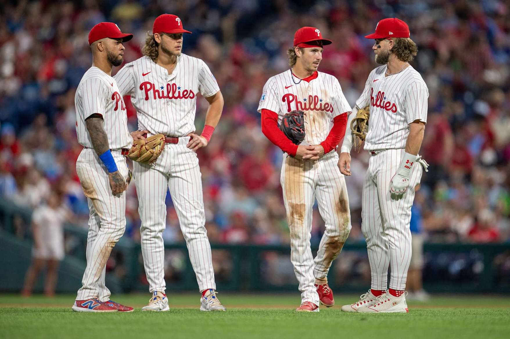 PHILADELPHIA, PA - AUGUST 14: Philadelphia Phillies first base Bryce Harper (3), Philadelphia Phillies shortstop Edmundo Sosa (33), Philadelphia Phillies third base Alec Bohm (28) and Philadelphia Phillies second base Bryson Stott (5) talk during the game between the Miami Marlins and the Philadelphia Phillies on August 14th, 2024 at Citizens Bank Park in Philadelphia, PA. (Photo by Terence Lewis/Icon Sportswire via Getty Images)