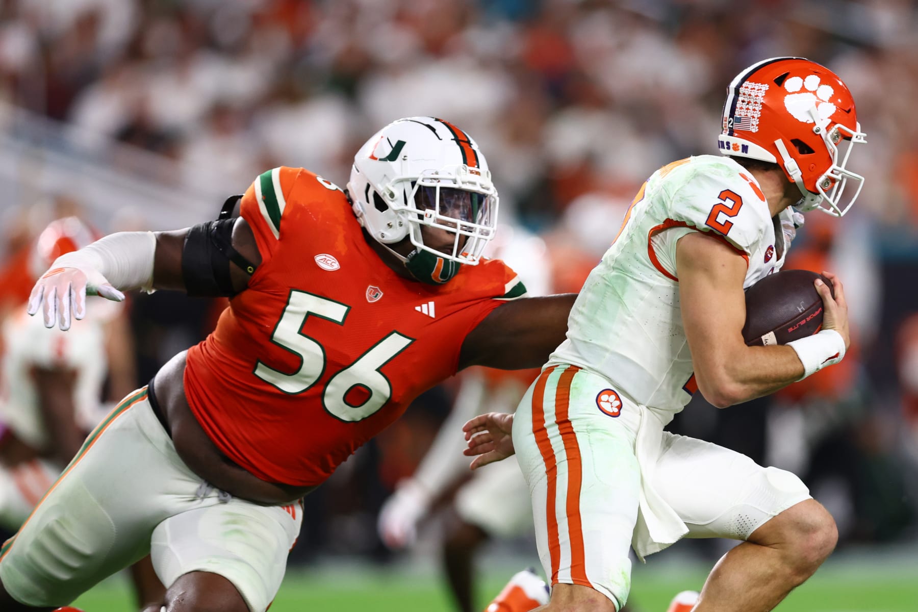 MIAMI GARDENS, FLORIDA - OCTOBER 21: Leonard Taylor III #56 of the Miami Hurricanes pressures Cade Klubnik #2 of the Clemson Tigers during the second half of the game at Hard Rock Stadium on October 21, 2023 in Miami Gardens, Florida. (Photo by Megan Briggs/Getty Images)