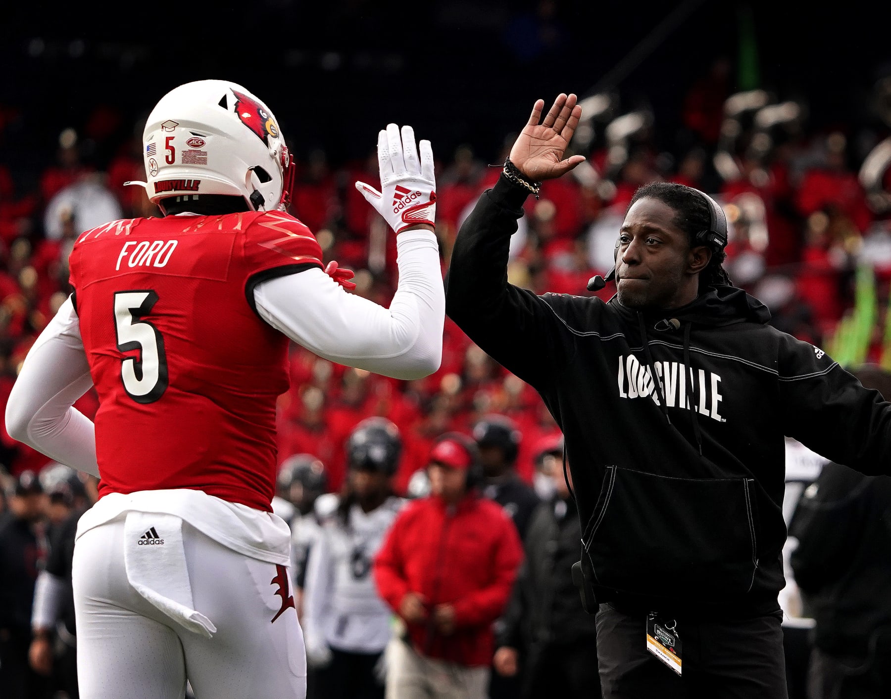 Boston, MA - December 17: Louisville Cardinals interim head coach Deion Branch high fives TE Marshon Ford after Ford scored a touchdown in the second quarter. The Cardinals beat the Cincinnati Bearcats 24-7 in the inaugural Wasabi Fenway Bowl. (Photo by Barry Chin/The Boston Globe via Getty Images)