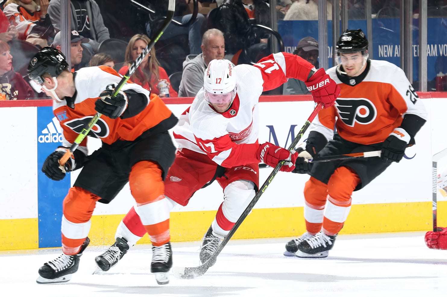 PHILADELPHIA, PENNSYLVANIA - DECEMBER 16: Daniel Sprong #17 of the Detroit Red Wings skates with the puck between Nick Seeler #24 and Sean Walker #26 of the Philadelphia Flyers during the third period at the Wells Fargo Center on December 16, 2023 in Philadelphia, Pennsylvania. (Photo by Tim Nwachukwu/Getty Images)