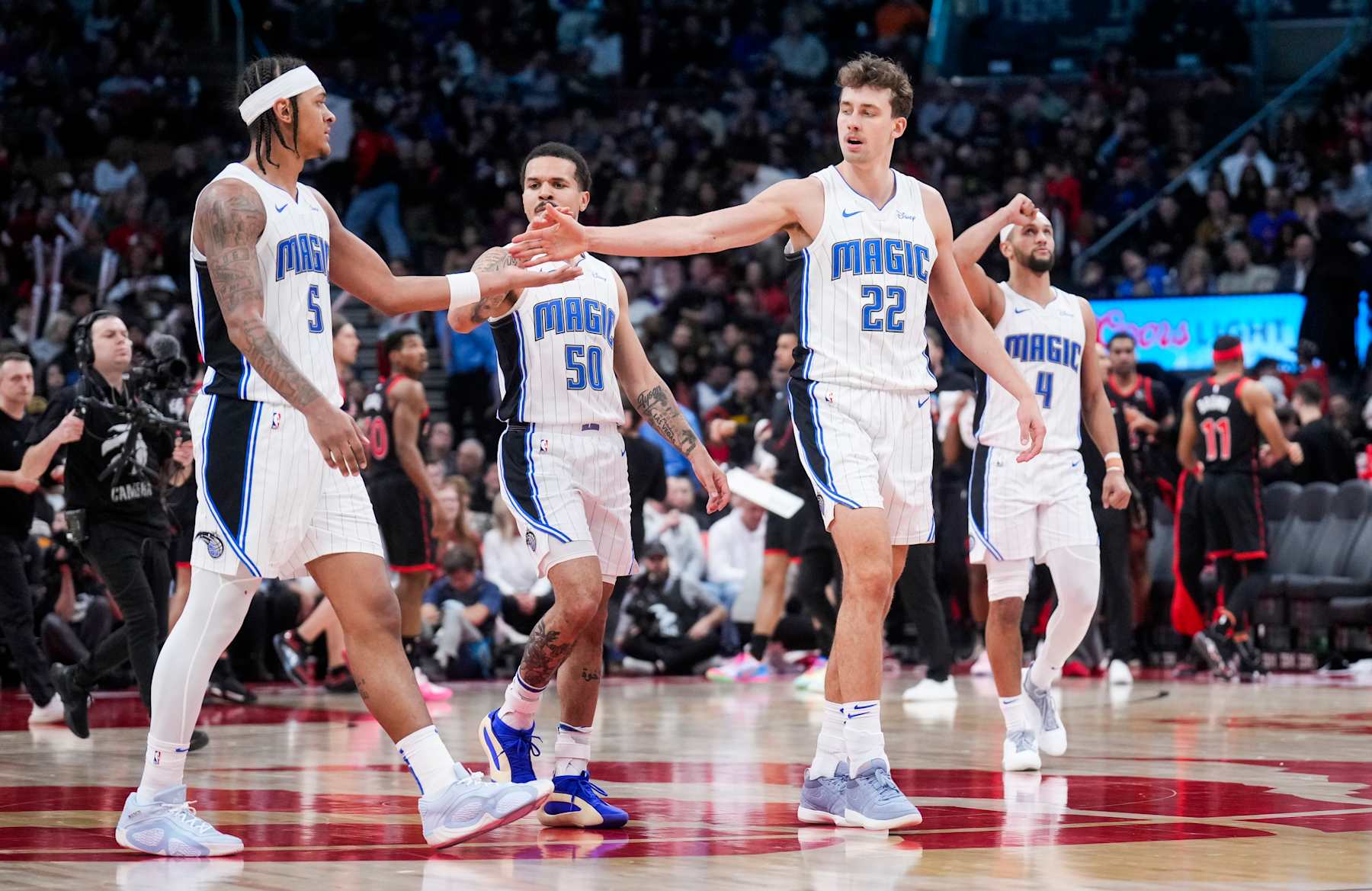 TORONTO, ON - MARCH 15: Paolo Banchero #5, Cole Anthony #50, Franz Wagner #22 and Jalen Suggs #4 of the Orlando Magic celebrate against the Toronto Raptors during the second half of their basketball game at the Scotiabank Arena on March 15, 2024 in Toronto, Ontario, Canada. NOTE TO USER: User expressly acknowledges and agrees that, by downloading and/or using this Photograph, user is consenting to the terms and conditions of the Getty Images License Agreement. (Photo by Mark Blinch/Getty Images)
