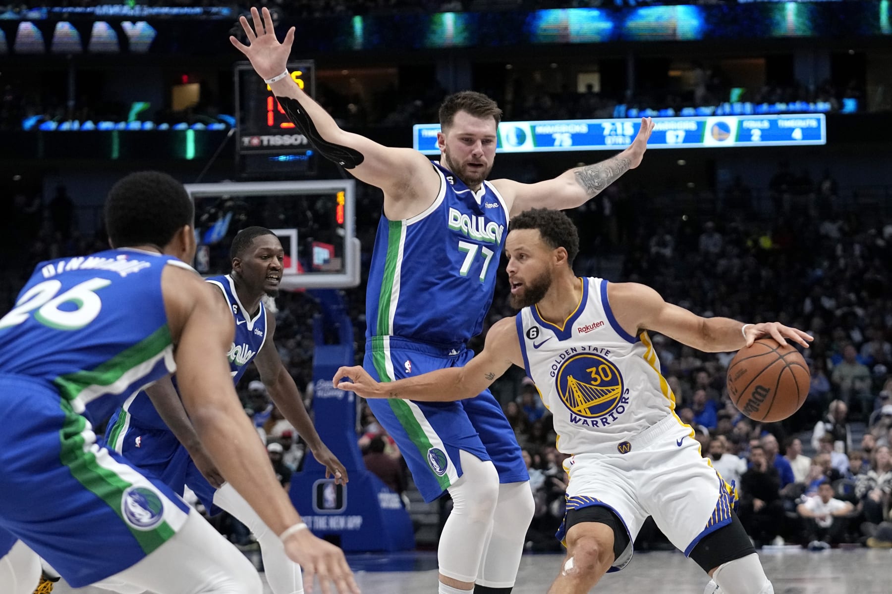 Golden State Warriors guard Stephen Curry (30) attempts to get to the basket as Dallas Mavericks' Spencer Dinwiddie (26), Dorian Finney-Smith, center left, and Luka Doncic (77) defend in the second half of an NBA basketball game in Dallas, Tuesday, Nov. 29, 2022. (AP Photo/Tony Gutierrez)