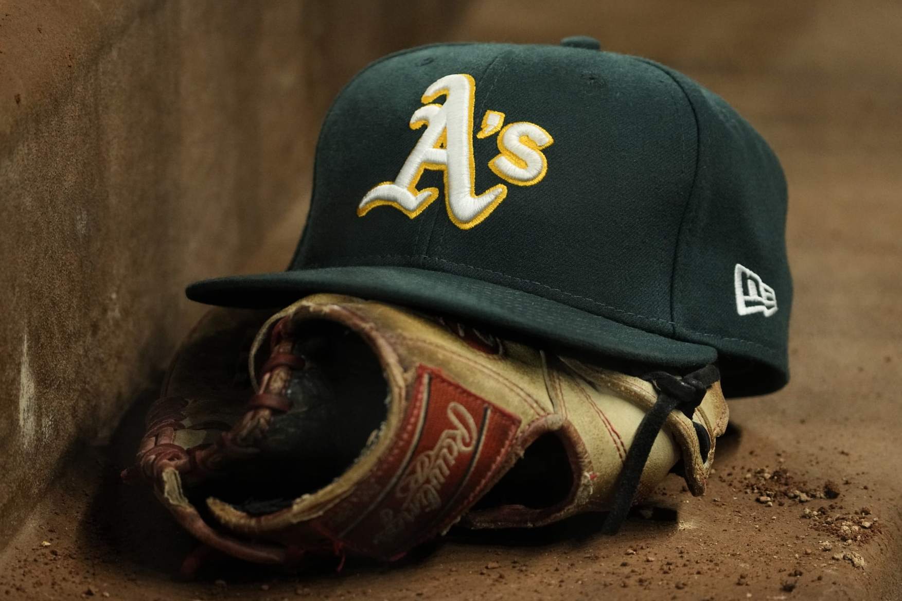 ARLINGTON, TEXAS - APRIL 21: A close up view of an Oakland Athletics hat and Rawlings glove during the game against the Texas Rangers at Globe Life Field on April 21, 2023 in Arlington, Texas. (Photo by Sam Hodde/Getty Images)