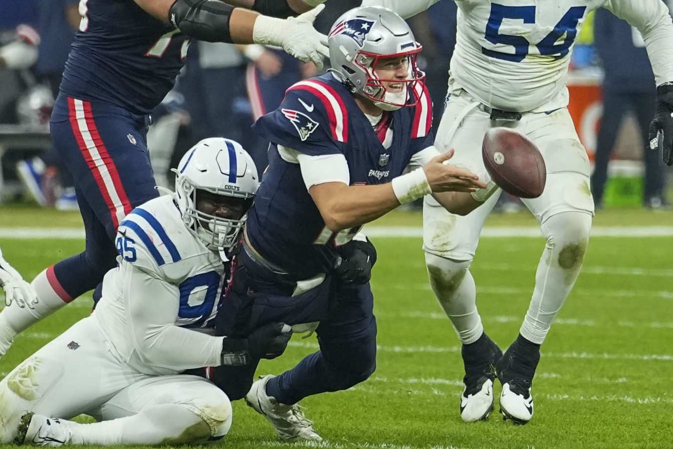 New England Patriots quarterback Mac Jones (10) pitches out as Indianapolis Colts defensive end Adetomiwa Adebawore (95) tries to tackle in the second half of an NFL football game in Frankfurt, Germany Sunday, Nov. 12, 2023. (AP Photo/Martin Meissner) New England Patriots quarterback Mac Jones (10) pitches out as Indianapolis Colts defensive end Adetomiwa Adebawore (95) tries to tackle in the second half of an NFL football game in Frankfurt, Germany Sunday, Nov. 12, 2023. (AP Photo/Martin Meissner)