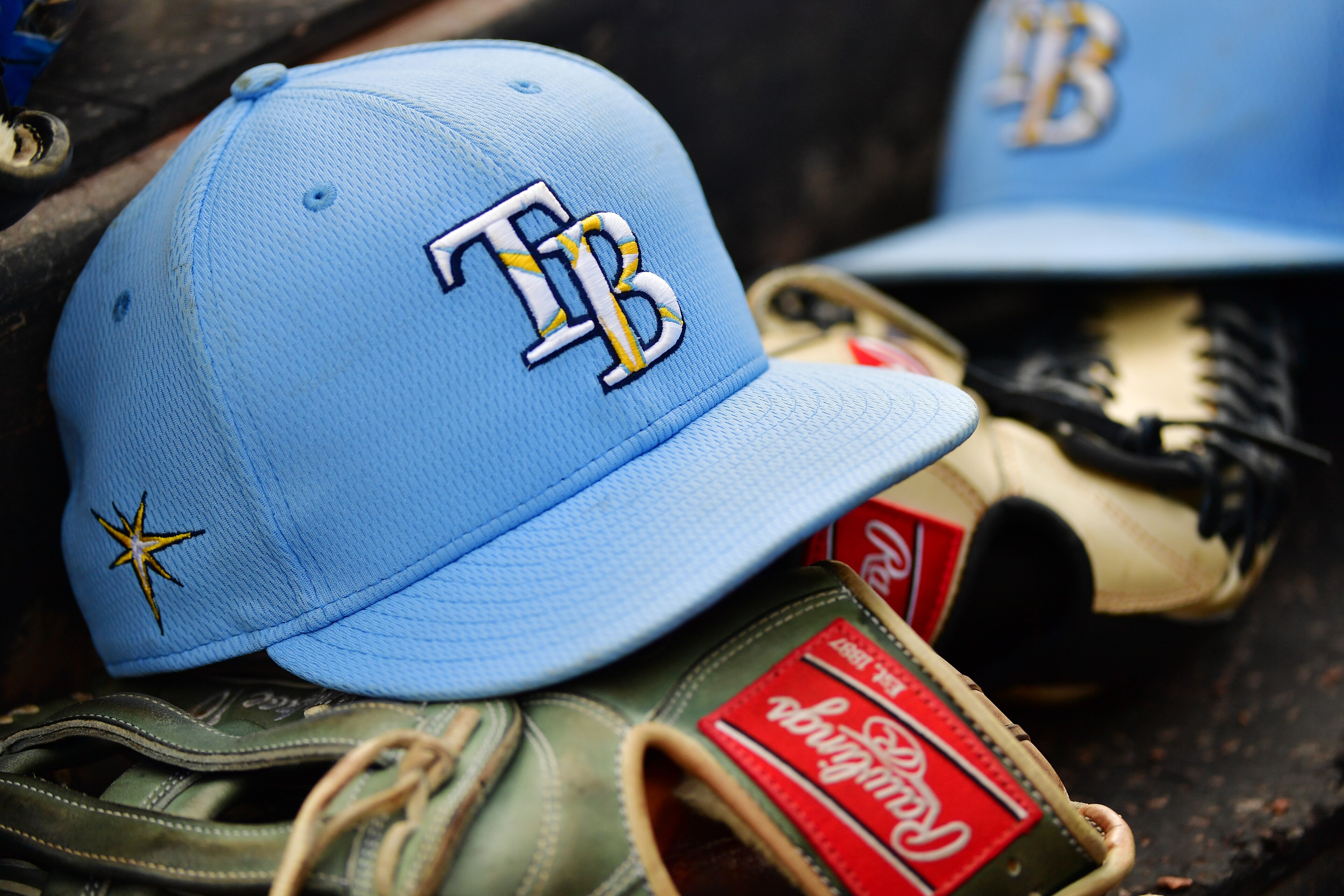 SARASOTA, FLORIDA - MARCH 02: A Tampa Bay Rays hat sits on top of a glove in the dugout during a Grapefruit League spring training game between the Baltimore Orioles and the Tampa Bay Rays at Ed Smith Stadium on March 02, 2020 in Sarasota, Florida. (Photo by Julio Aguilar/Getty Images)