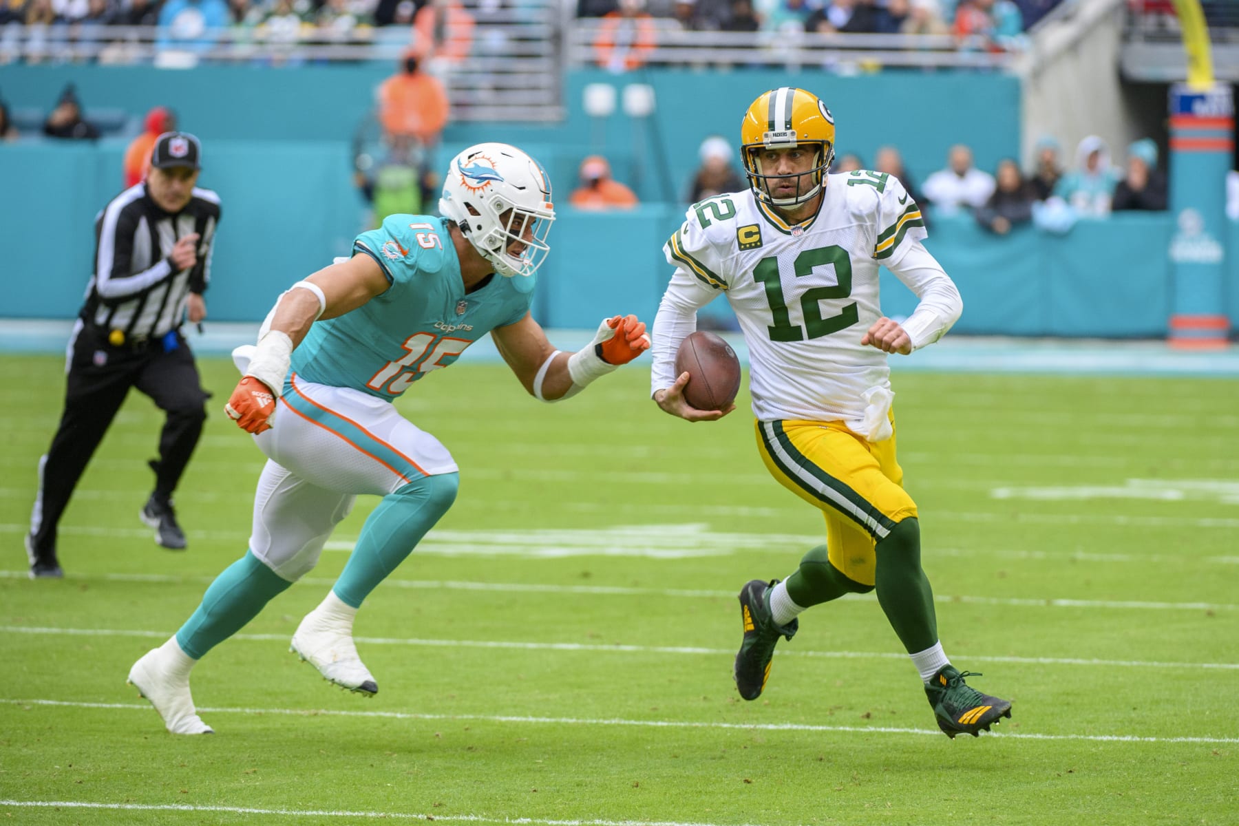 Green Bay Packers quarterback Aaron Rodgers (12) runs with the ball and is tackled by Miami Dolphins linebacker Jaelan Phillips (15) during an NFL football game Sunday, Dec. 25, 2022, in Miami Gardens, Fla. (AP Photo/Doug) Murray)