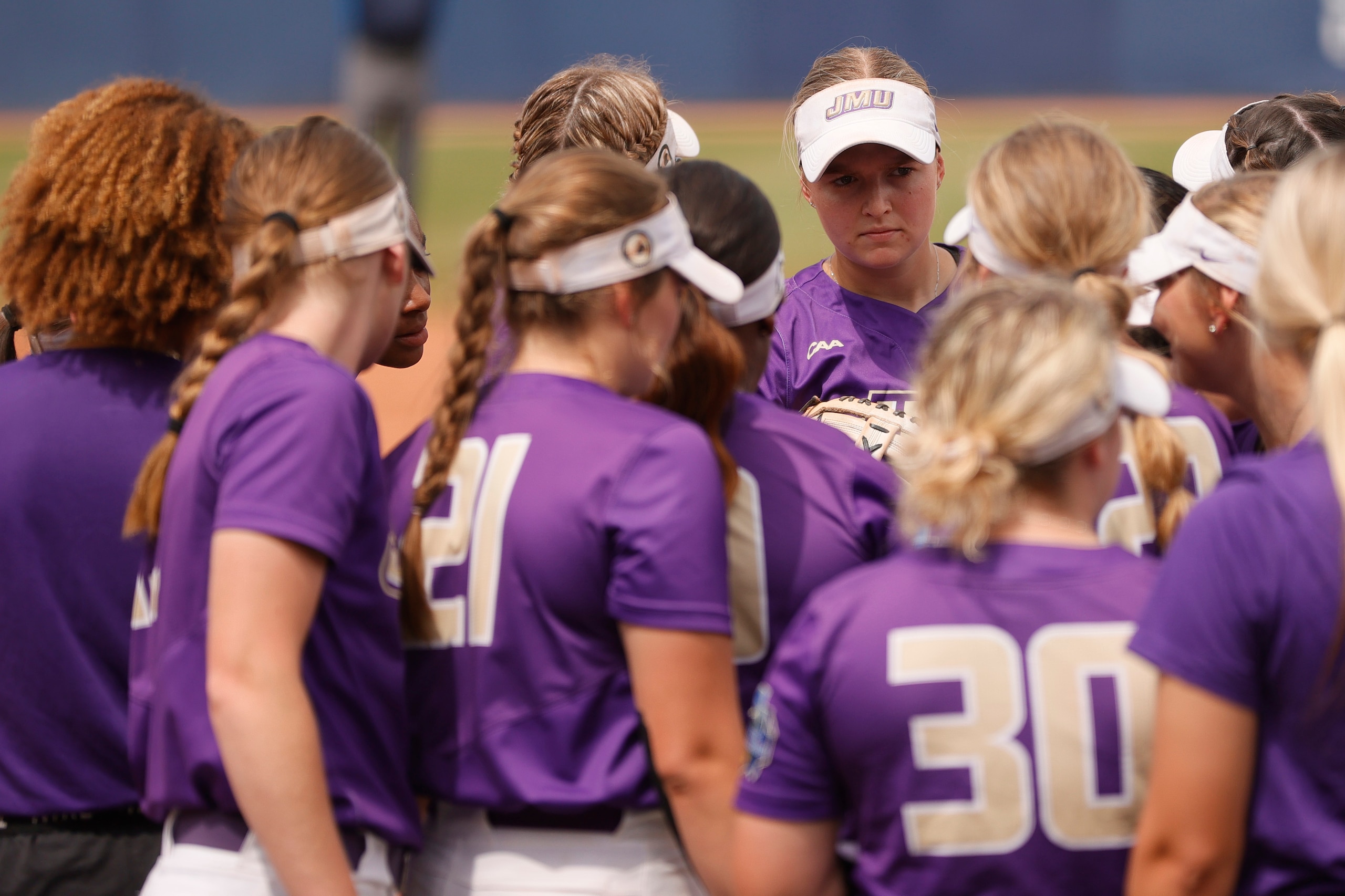 OKLAHOMA CITY, OKLAHOMA - JUNE 07: James Madison players huddle during the second inning of Game 13 of the Women's College World Series against Oklahoma on June 07, 2021 at USA Softball Hall of Fame Stadium in Oklahoma City, Oklahoma. Oklahoma won 7-1. (Photo by Sarah Stier/Getty Images) OKLAHOMA CITY, OKLAHOMA - JUNE 07: James Madison players huddle during the second inning of Game 13 of the Women's College World Series against Oklahoma on June 07, 2021 at USA Softball Hall of Fame Stadium in Oklahoma City, Oklahoma. Oklahoma won 7-1. (Photo by Sarah Stier/Getty Images)