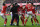 A supporter is tackled by stewards as Nottingham Forest's English defender Joe Worrall celebrates with his teammates after scoring their third goal during the English FA Cup fourth round football match between Nottingham Forest and Leicester City at The City Ground in Nottingham, central England, on February 6, 2022. - - RESTRICTED TO EDITORIAL USE. No use with unauthorized audio, video, data, fixture lists, club/league logos or 'live' services. Online in-match use limited to 120 images. An additional 40 images may be used in extra time. No video emulation. Social media in-match use limited to 120 images. An additional 40 images may be used in extra time. No use in betting publications, games or single club/league/player publications. (Photo by JUSTIN TALLIS / AFP) / RESTRICTED TO EDITORIAL USE. No use with unauthorized audio, video, data, fixture lists, club/league logos or 'live' services. Online in-match use limited to 120 images. An additional 40 images may be used in extra time. No video emulation. Social media in-match use limited to 120 images. An additional 40 images may be used in extra time. No use in betting publications, games or single club/league/player publications. / RESTRICTED TO EDITORIAL USE. No use with unauthorized audio, video, data, fixture lists, club/league logos or 'live' services. Online in-match use limited to 120 images. An additional 40 images may be used in extra time. No video emulation. Social media in-match use limited to 120 images. An additional 40 images may be used in extra time. No use in betting publications, games or single club/league/player publications. (Photo by JUSTIN TALLIS/AFP via Getty Images)