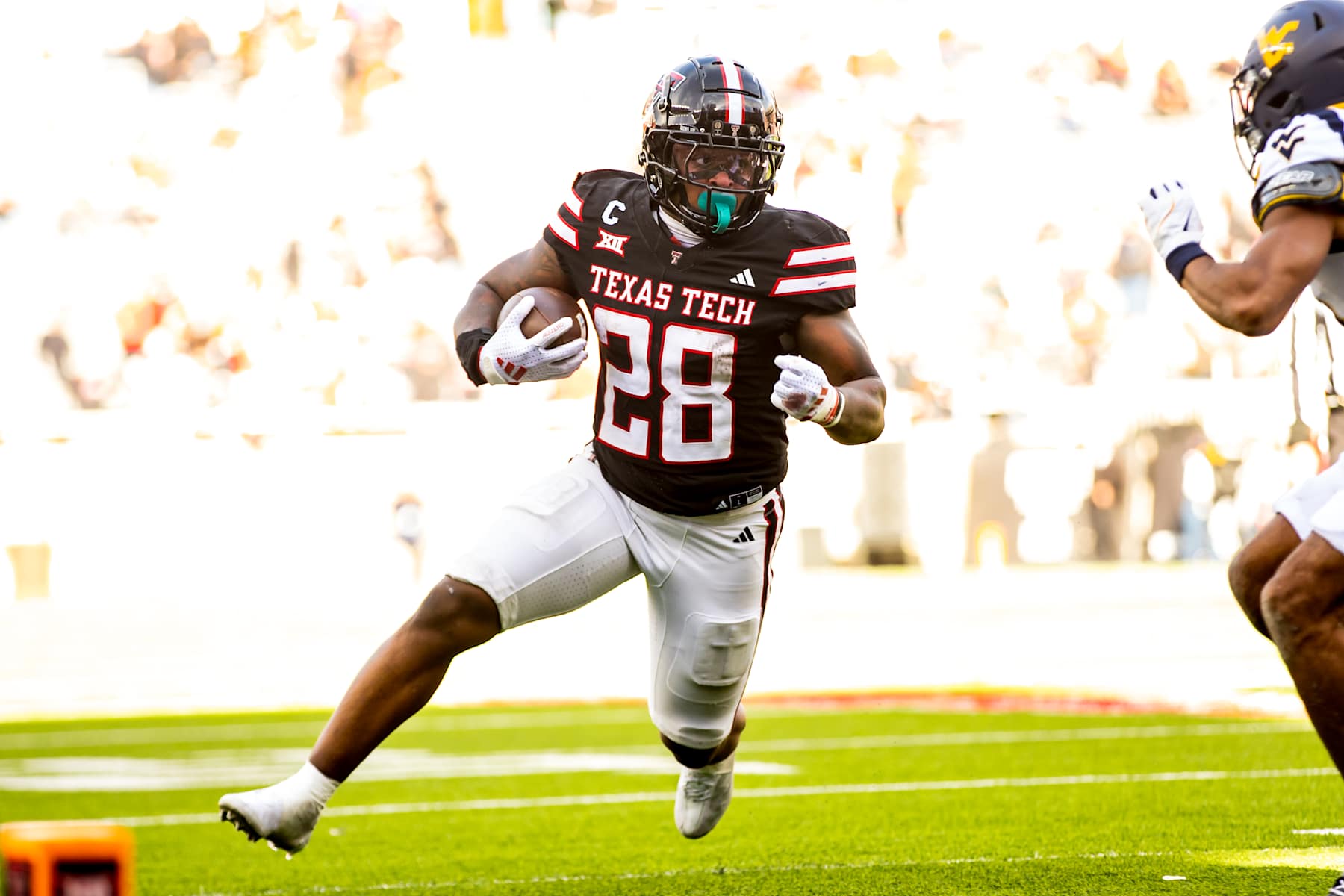 LUBBOCK, TEXAS - NOVEMBER 30: Tahj Brooks #28 of the Texas Tech Red Raiders runs the ball during the second half of the game against the West Virginia Mountaineers at Jones AT&T Stadium on November 30, 2024 in Lubbock, Texas.  (Photo by John E. Moore III/Getty Images)