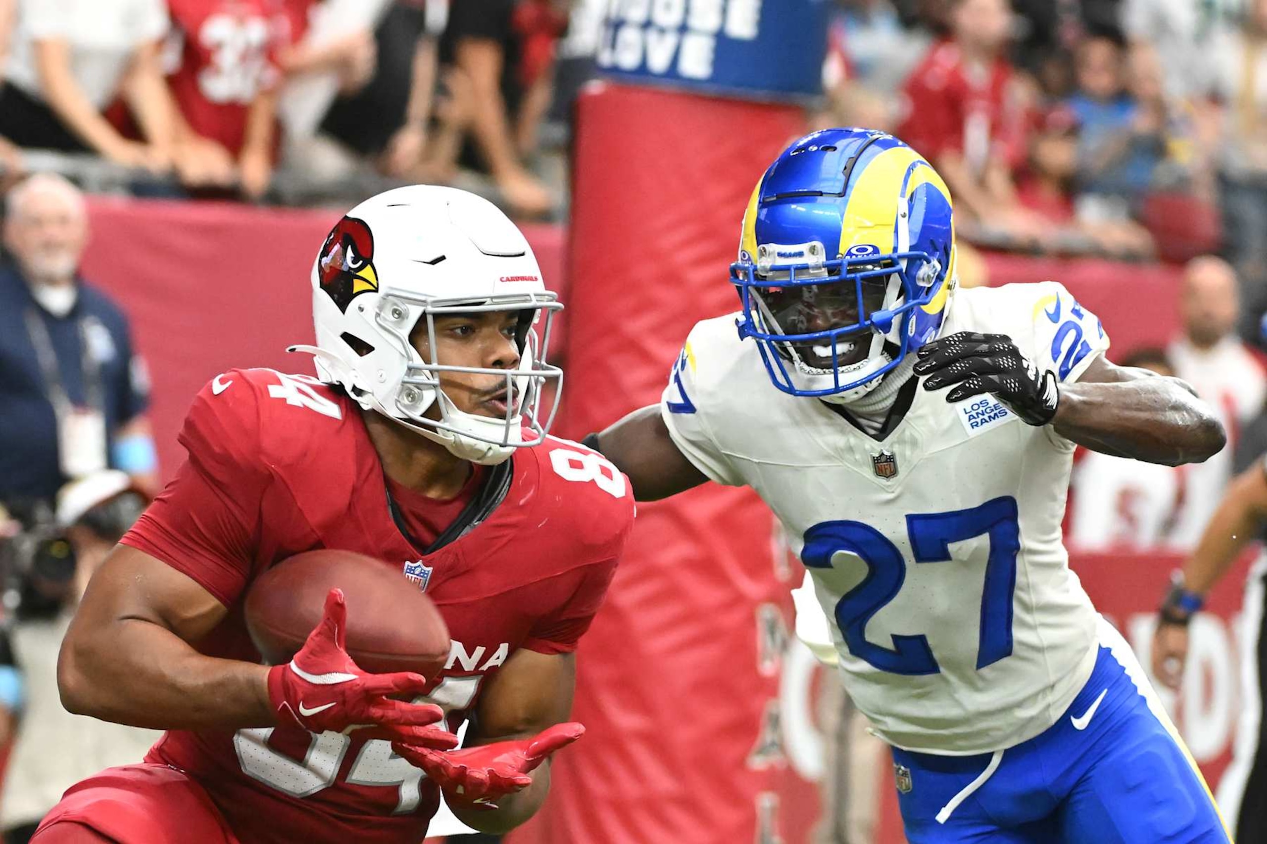 GLENDALE, ARIZONA - SEPTEMBER 15: Elijah Higgins #84 of the Arizona Cardinals catches a touchdown pass in front of Tre'Davious White #27 of the Los Angeles Rams during the second quarter at State Farm Stadium on September 15, 2024 in Glendale, Arizona. (Photo by Norm Hall/Getty Images) GLENDALE, ARIZONA - SEPTEMBER 15: Elijah Higgins #84 of the Arizona Cardinals catches a touchdown pass in front of Tre'Davious White #27 of the Los Angeles Rams during the second quarter at State Farm Stadium on September 15, 2024 in Glendale, Arizona. (Photo by Norm Hall/Getty Images)
