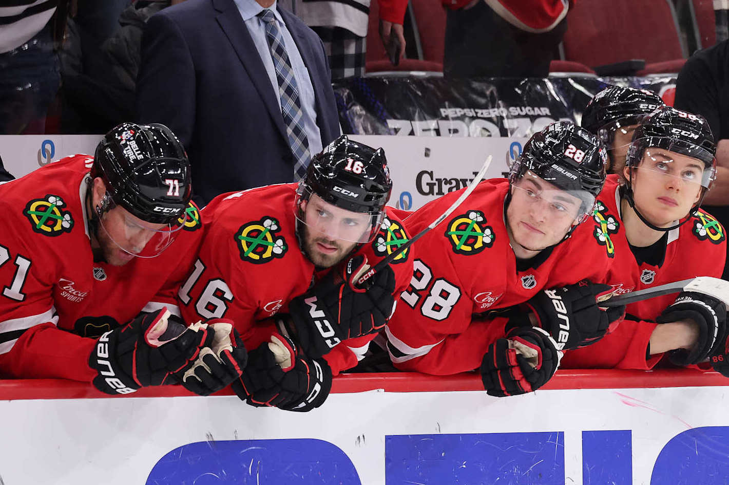 CHICAGO, ILLINOIS - JANUARY 05: Taylor Hall #71, Jason Dickinson #16, Colton Dach #28 and Connor Bedard #98 of the Chicago Blackhawks look on against the New York Rangers during the third period at the United Center on January 05, 2025 in Chicago, Illinois. (Photo by Michael Reaves/Getty Images)