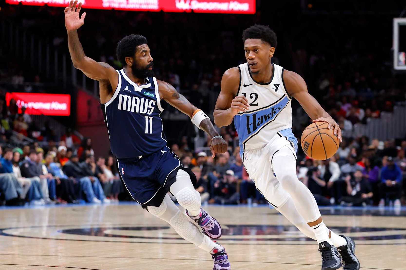 ATLANTA, GEORGIA - NOVEMBER 25: De'Andre Hunter #12 of the Atlanta Hawks drives against Kyrie Irving #11 of the Dallas Mavericks during the third quarter at State Farm Arena on November 25, 2024 in Atlanta, Georgia. NOTE TO USER: User expressly acknowledges and agrees that, by downloading and or using this photograph, User is consenting to the terms and conditions of the Getty Images License Agreement. (Photo by Todd Kirkland/Getty Images)