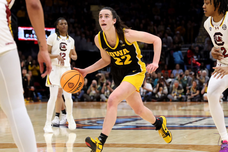 CLEVELAND, OHIO - APRIL 07: Caitlin Clark #22 of the Iowa Hawkeyes dribbles as Ashlyn Watkins #2 of the South Carolina Gamecocks looks on in the first half during the 2024 NCAA Women's Basketball Tournament National Championship at Rocket Mortgage FieldHouse on April 07, 2024 in Cleveland, Ohio. (Photo by Gregory Shamus/Getty Images)