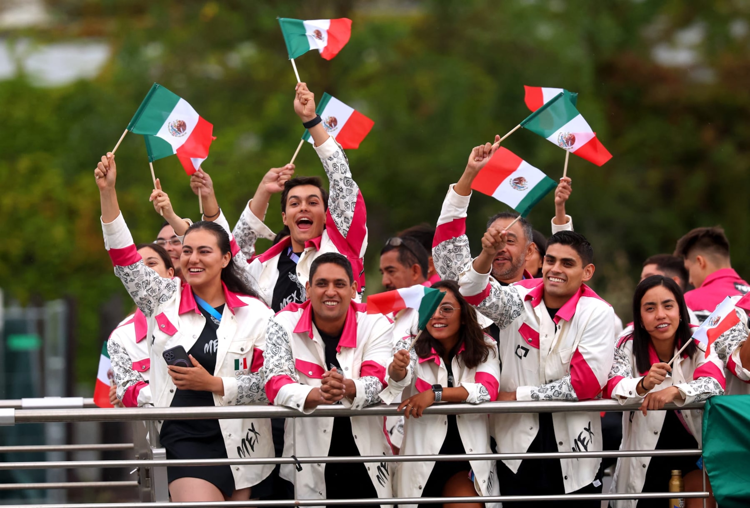 PARIS, FRANCE - JULY 26: Athletes of Team Mexico wave handheld flags as they cruise during the athletes' parade on the River Seine during the opening ceremony of the Olympic Games Paris 2024 on July 26, 2024 in Paris, France. (Photo by Michael Reaves / POOL / AFP) (Photo by MICHAEL REAVES/POOL/AFP via Getty Images)