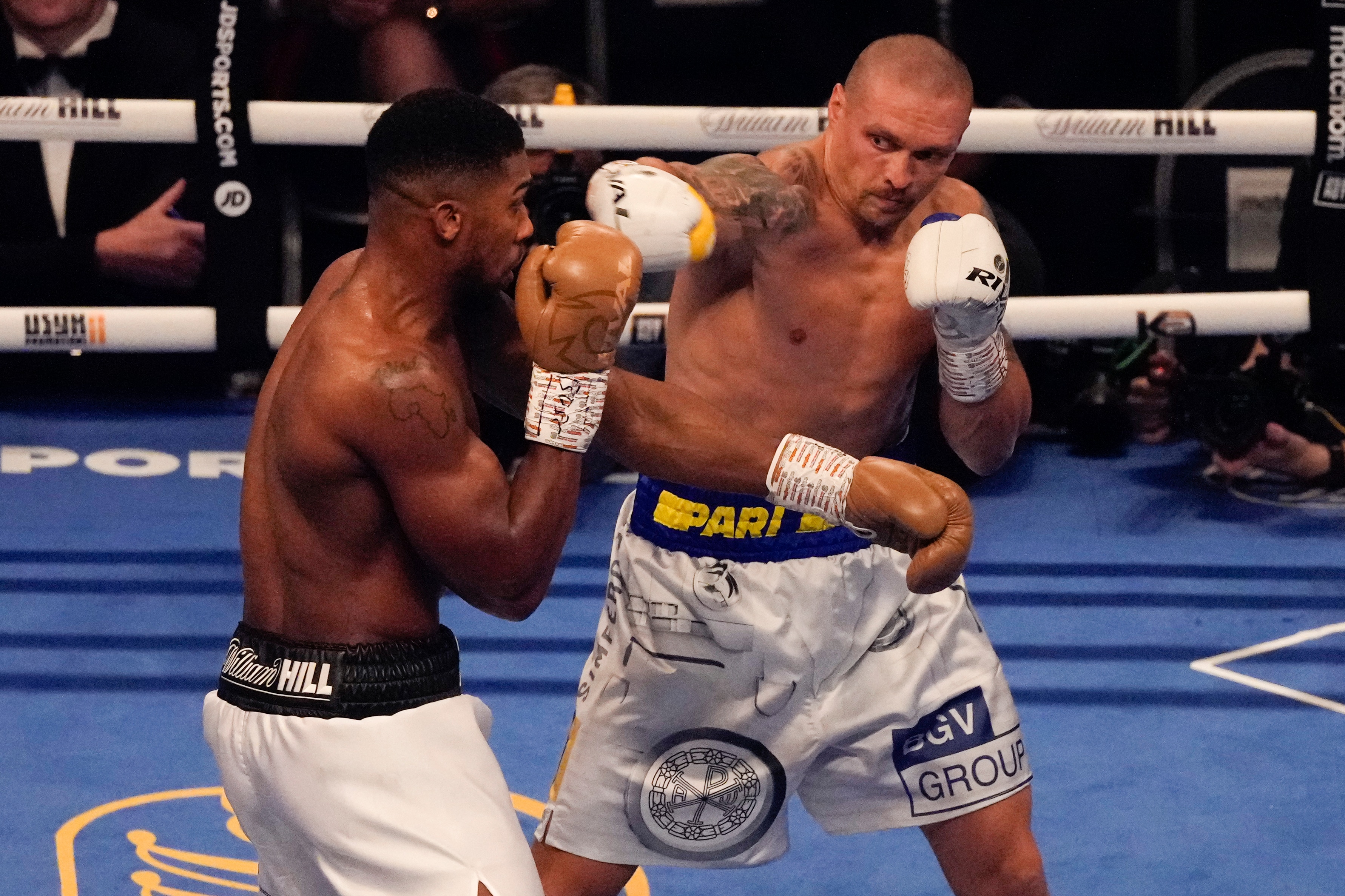 Oleksandr Usyk of Ukraine, left, throws a punch at Anthony Joshua of Britain during their WBA (Super), WBO and IBF boxing title bout at the Tottenham Hotspur Stadium in London, Saturday, Sept. 25, 2021. (AP Photo/Frank Augstein)